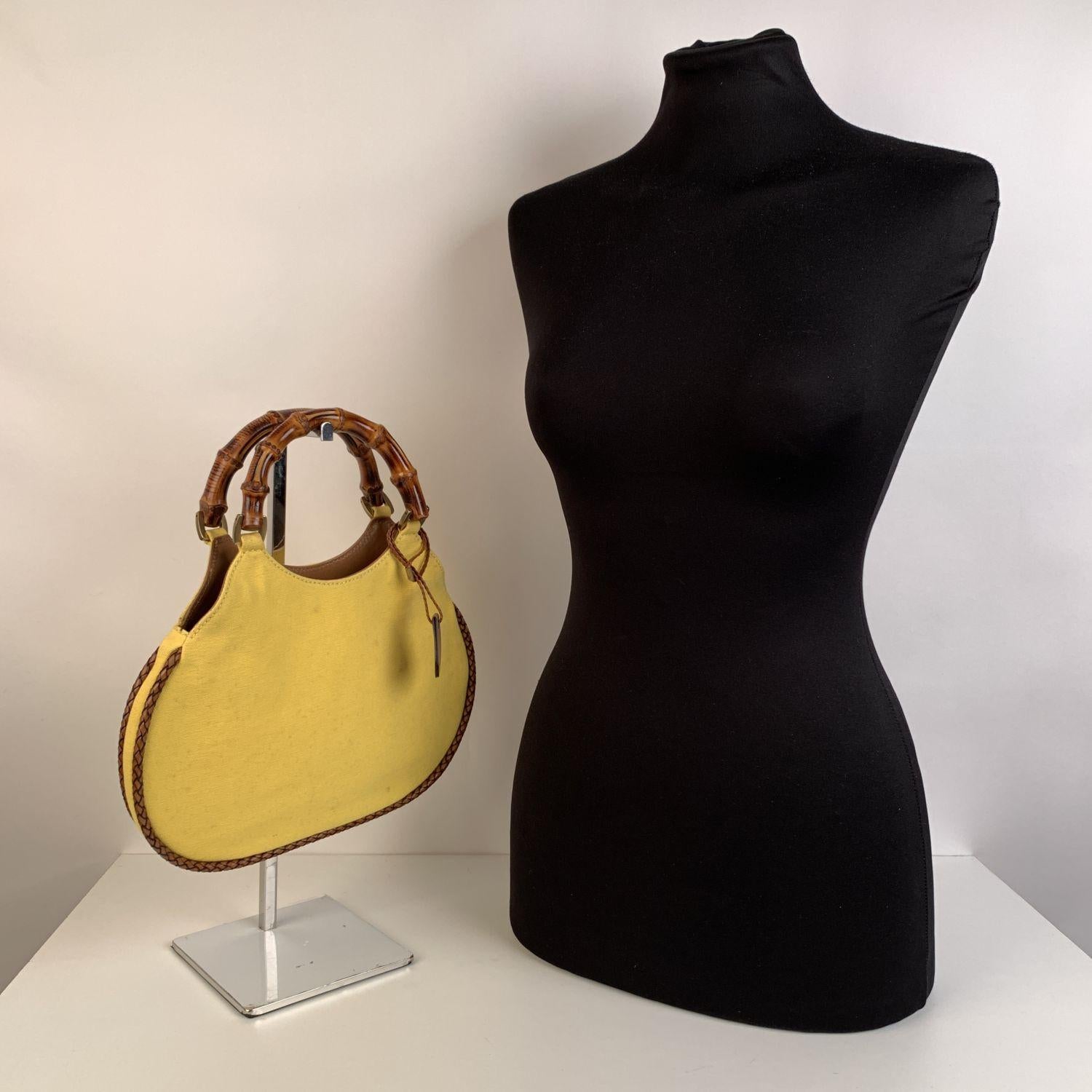 Beautiful Gucci small Bamboo tote bag. Crafted in yellow canvas with genuine leather braided trim. Double distinctive Bamboo handles.Open top. 1 side zip pocket inside. 'Gucci - Made in Italy' tag inside (serial number on its