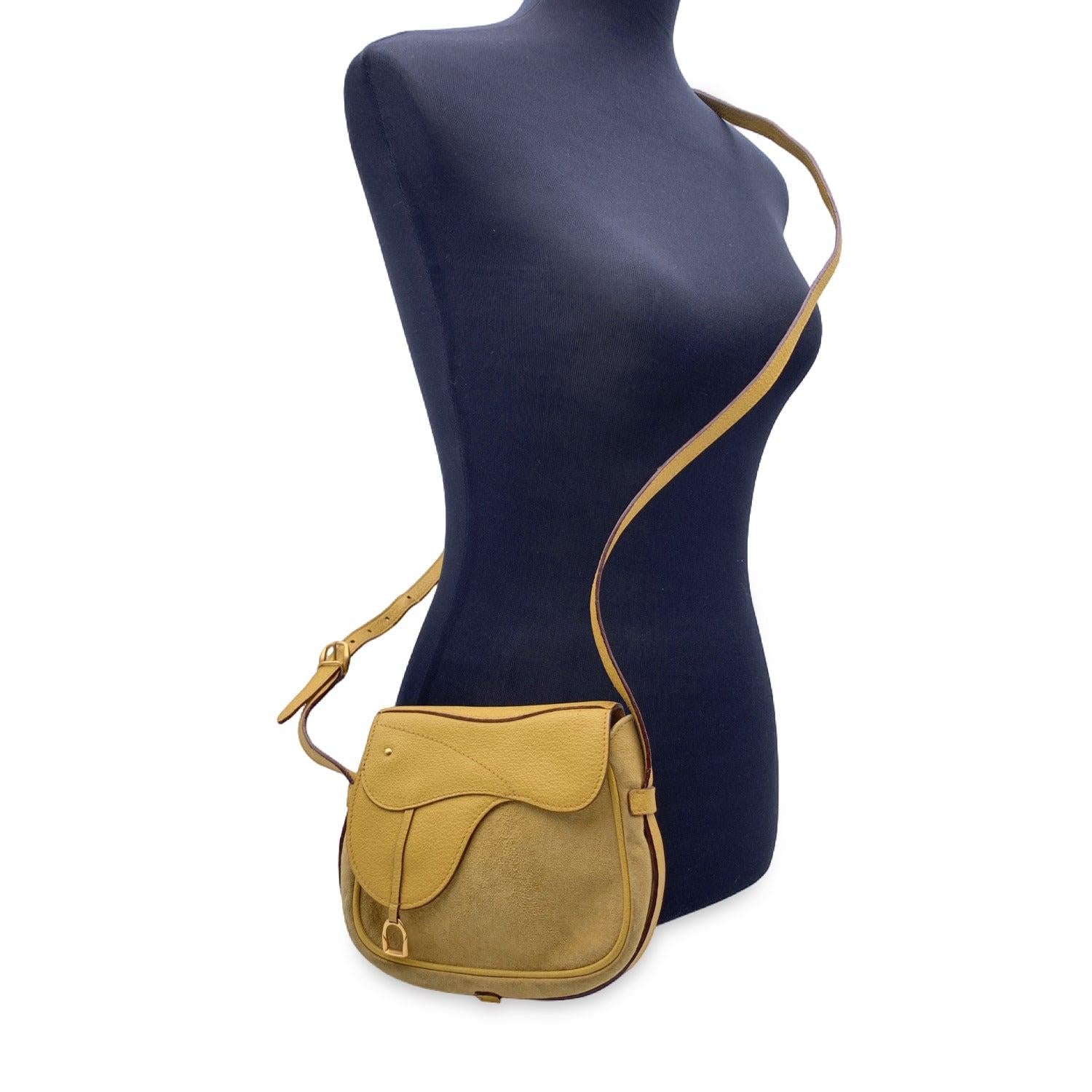 Gucci vintage shoulder bag in yellow suede and leather with saddle design. Convertible model: the bag can be worn crossbody style as well as a belt bag, thanks to 2 belt loops on the back. Flap with magnetic button closure on the front. It features