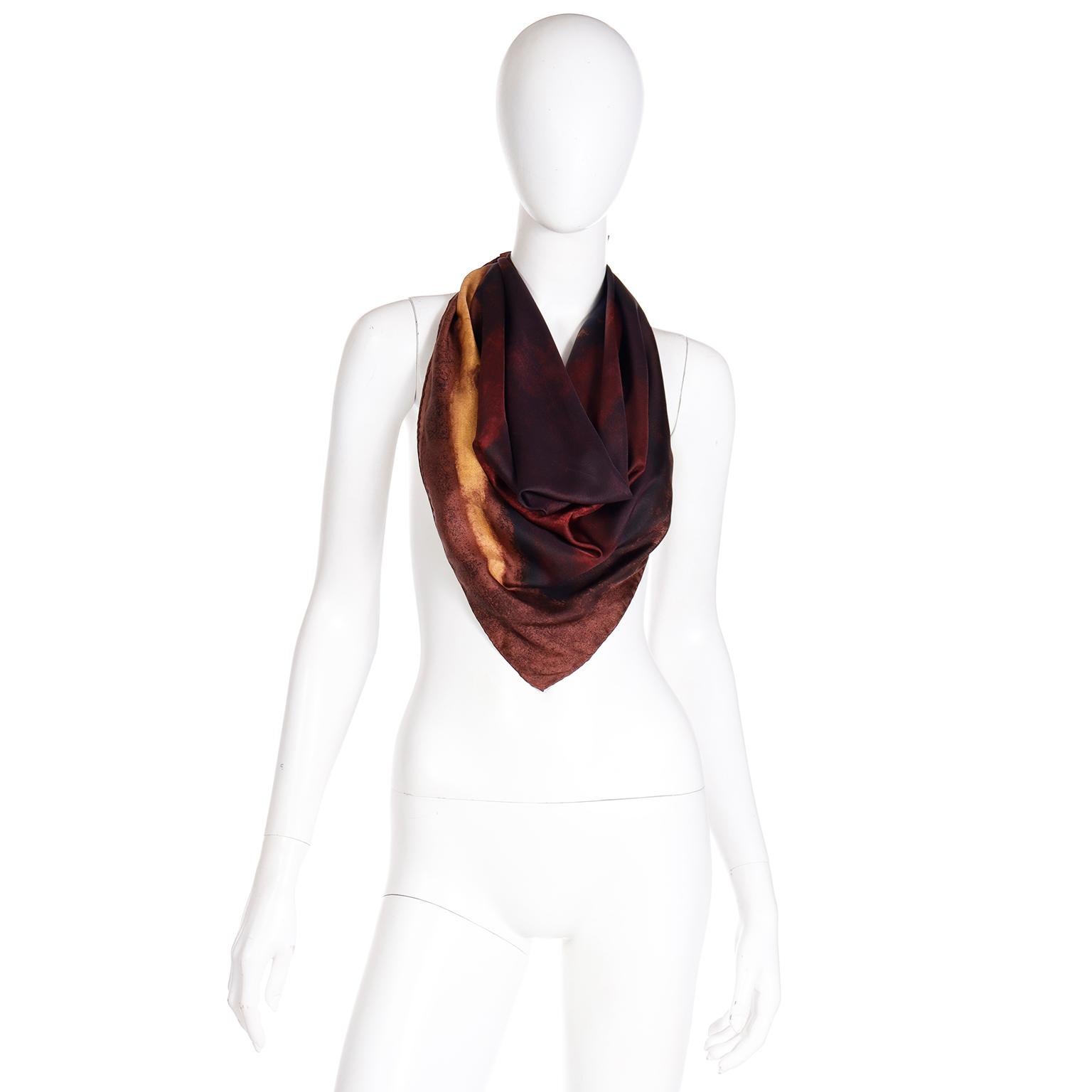 This incredible vintage Gucci silk scarf is in gorgeous watercolor shades of chocolate brown, dark brown, black, burgundy and gold. The front features a large center 