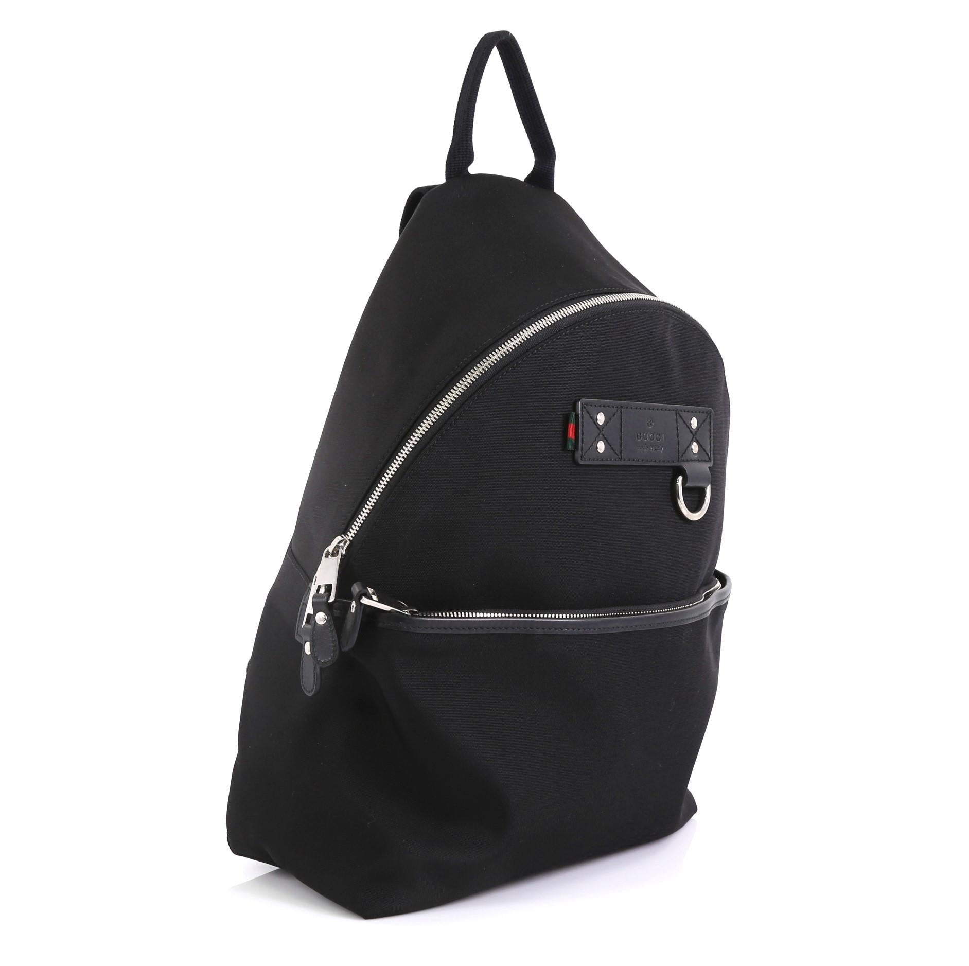 This Gucci Web Band Backpack Techno Canvas Medium, crafted from black canvas, features adjustable straps, front zip pocket and silver-tone hardware. Its zip closure opens to a black nylon interior with zip and slip pockets. 

Estimated Retail Price: