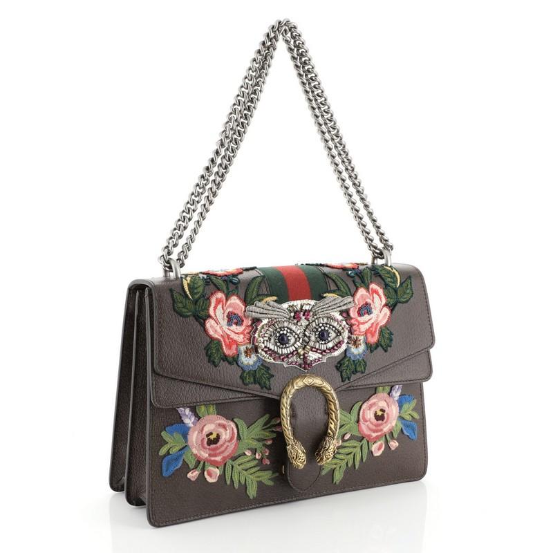 This Gucci Web Dionysus Bag Embellished Leather Medium, crafted from brown embellished leather, features chain link strap, textured tiger head spur detail on its flap and aged gold-tone hardware. Its hidden push-pin closure opens to a neutral
