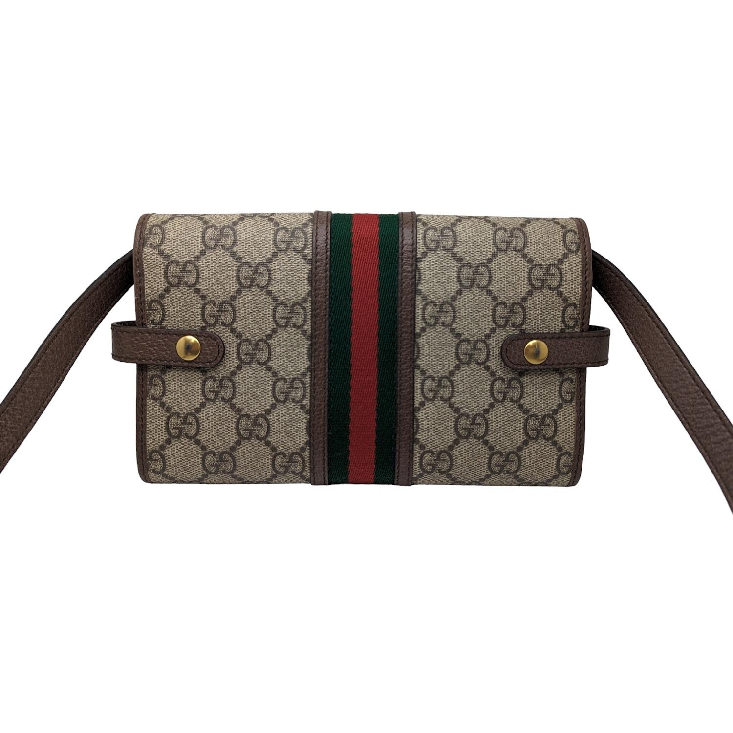 This stylish crossbody is crafted of Gucci GG monogram coated canvas with a green and red web stripe and brown leather trim. This wallet features a snap button closure in aged gold and an optional shoulder strap. The flap opens to a brown leather