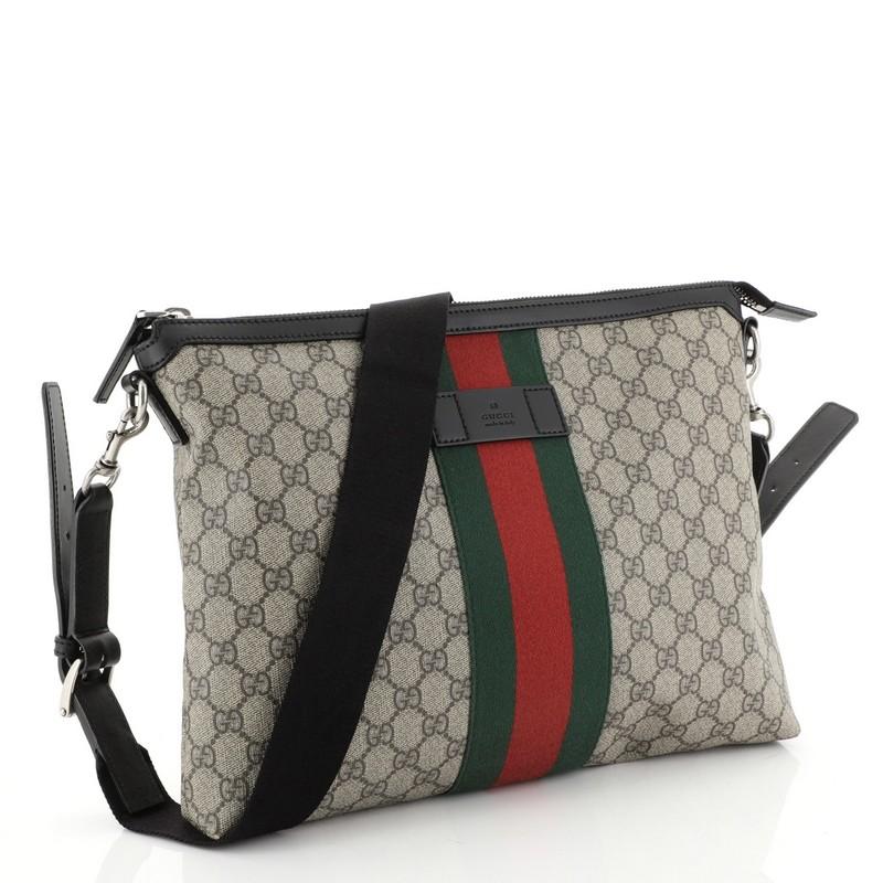 This Gucci Web Messenger Bag GG Coated Canvas Large, crafted from brown GG coated canvas, features an adjustable shoulder strap, leather trims, signature web detailing and aged silver-tone hardware. Its zip closure opens to a black fabric-lined