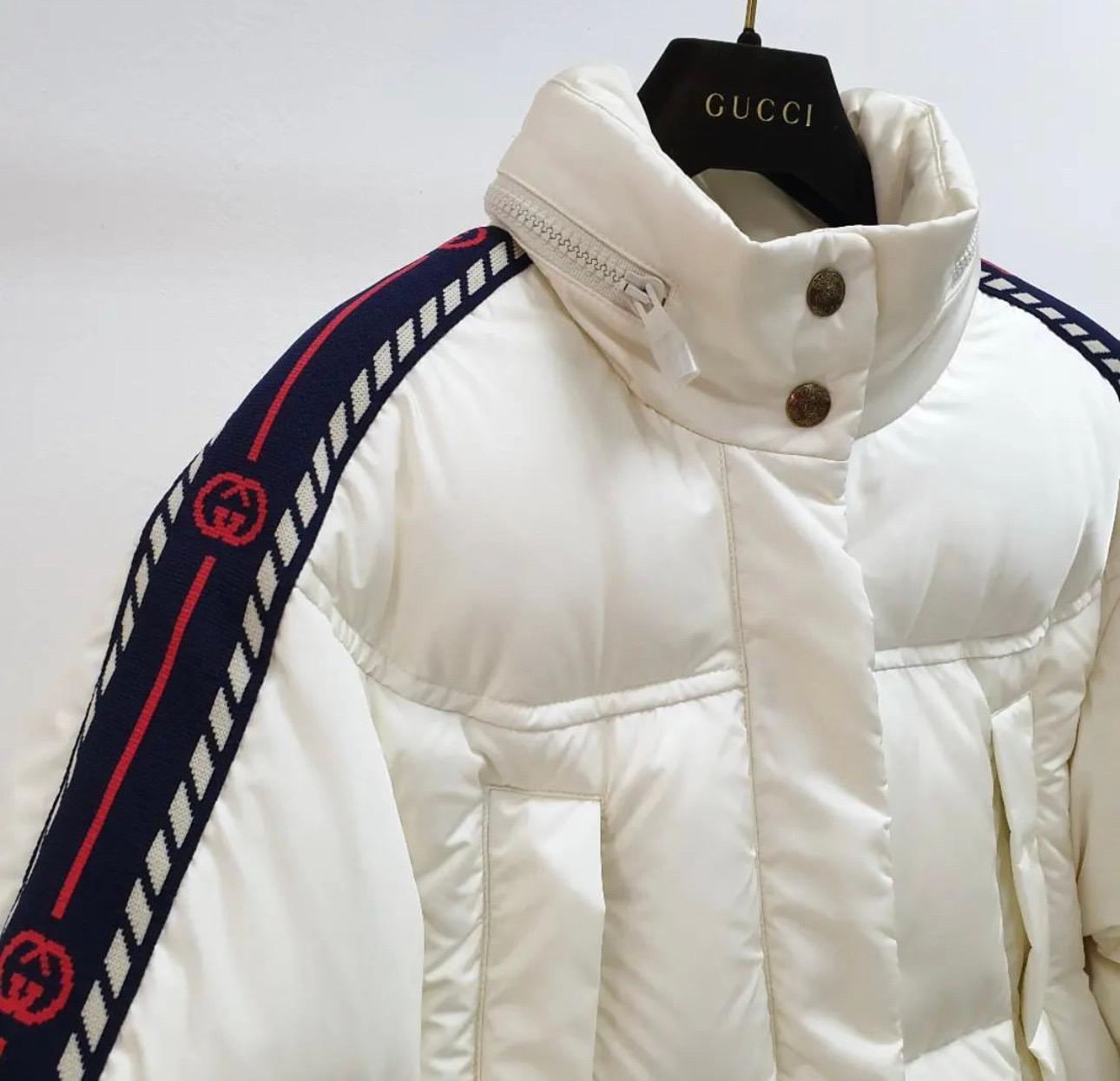 Web detailing down the sleeves of this white padded jacket give it the signature Gucci flair. The high neck will ensure you're kept cosy as winter kicks in. 
Featuring a stand up collar, a snap fastening, long sleeves, front flap pockets and GG thin