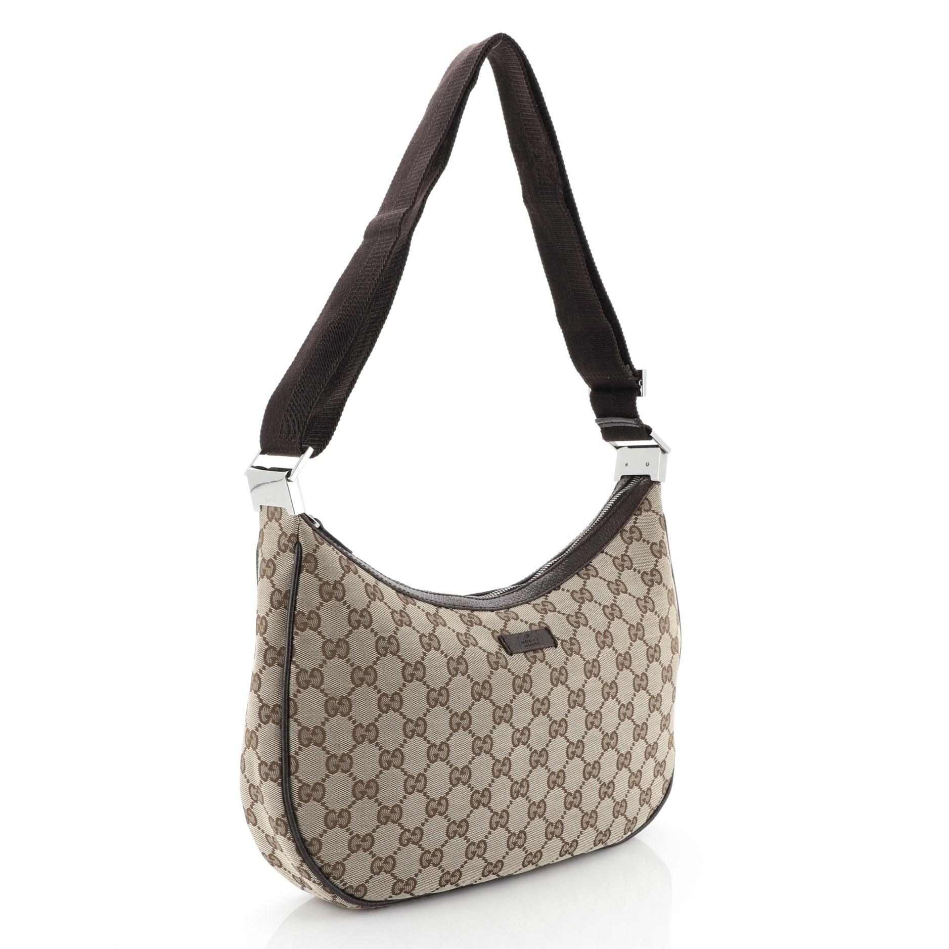 This Gucci Web Saddle Messenger GG Canvas Medium, crafted in brown GG canvas, features web shoulder strap, leather trim, and silver-tone hardware. Its zip closure opens to a brown fabric interior with side zip and slip pockets. 

Estimated Retail