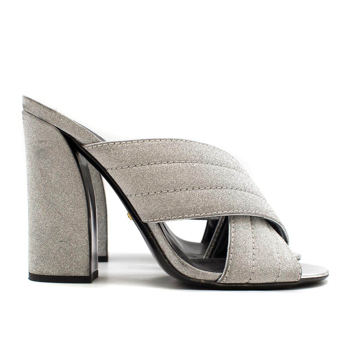 Gucci Webby Metallic Silver Mules

- 'Webby' Metallic Silver Mules
- Covered curved block heel 
- Quilted CrissCross vamp strap at front 
- Open toe, Slide style.
- Leather 
- Padded leather insole printed with gold-tone foil branding

Please note,