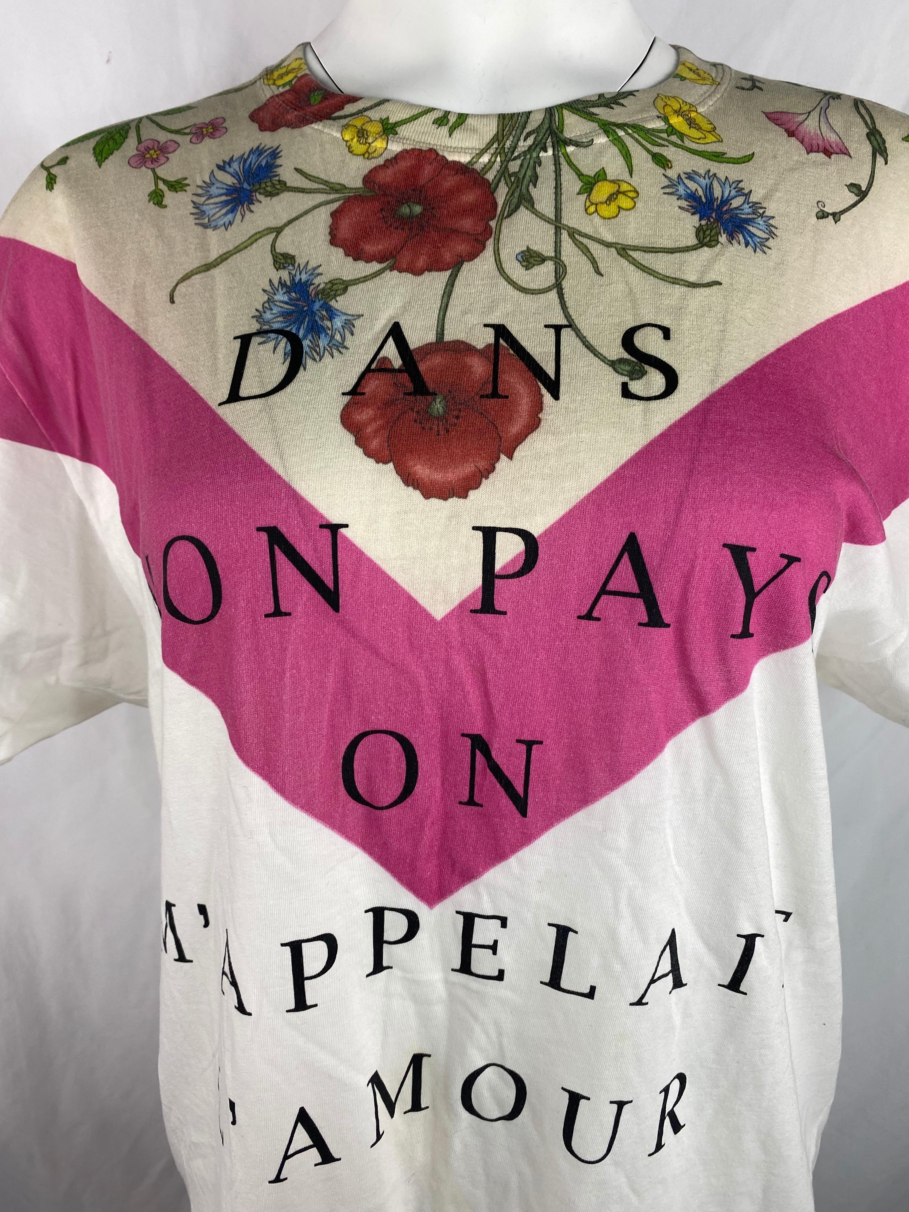 Product details:

The top features floral print on the front with Dans Mon Pays On M'Appelait L'Amour black print, crew neck line and short sleeves.