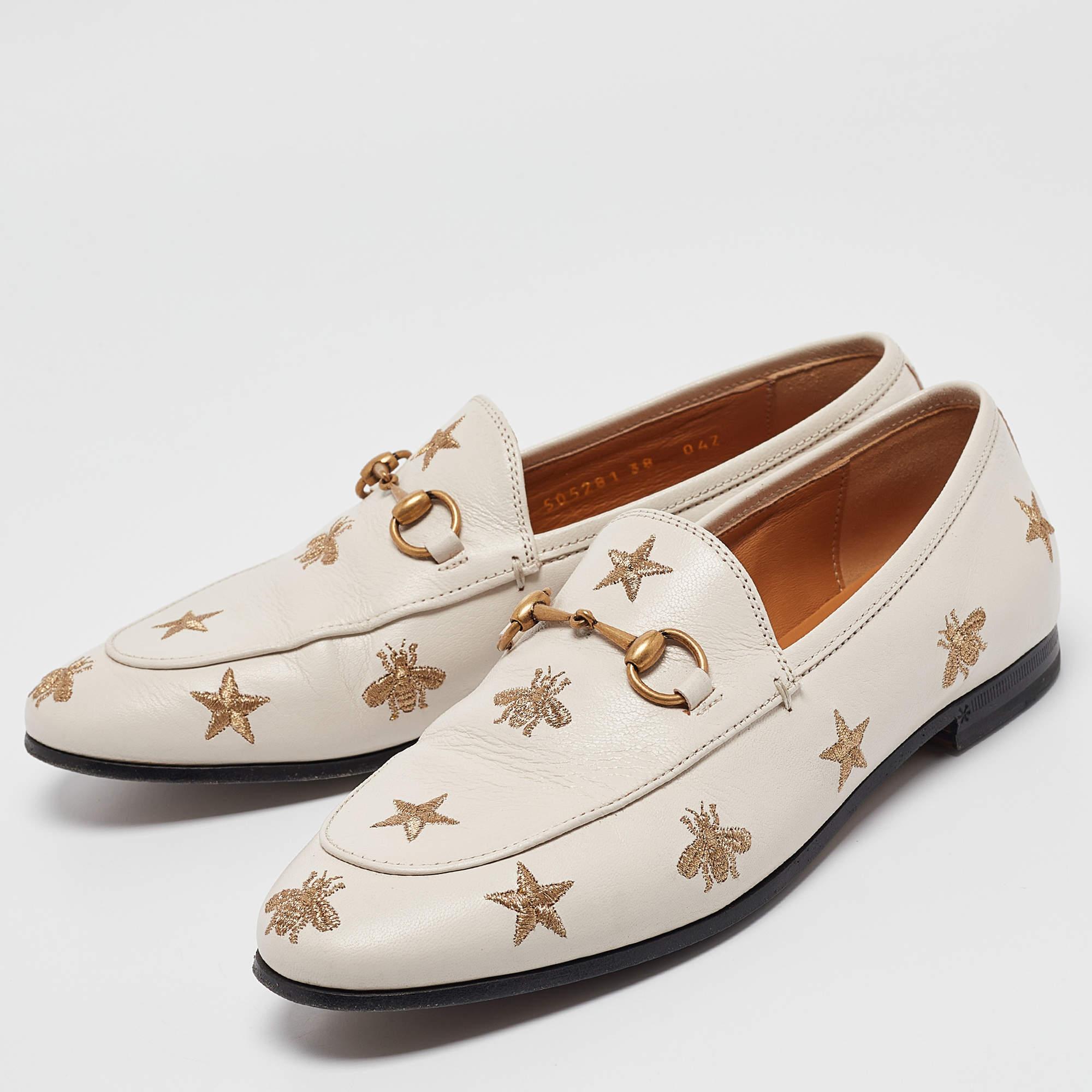 The Jordaan is a shoe that has a modern finish and a signature appeal. It has an elongated toe and the Gucci Horsebit motif gracing the uppers. This pair in white is crafted from leather and features bee and star motifs all over.