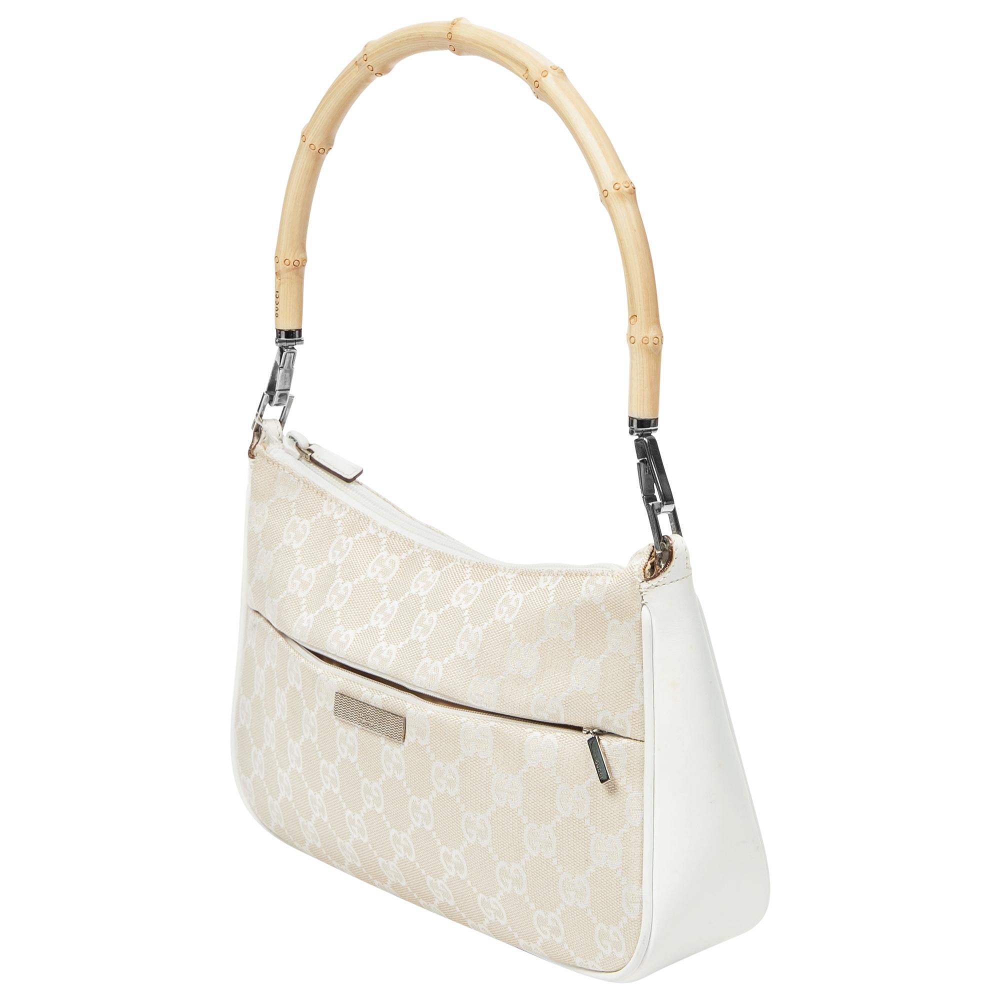 Mit der weiß/beigen GG Bamboo Shoulder Bag von Gucci können Sie Ihren Alltagsstil aufwerten. Sie ist aus strapazierfähigem Canvas in einem schicken Beige-Ton gefertigt und strahlt unaufdringliche Raffinesse aus. Die Tasche ist mit silberfarbenen