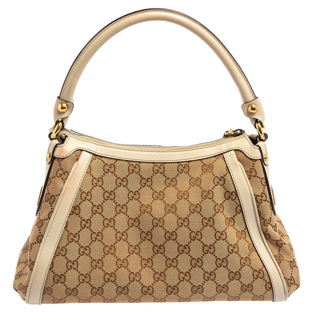 It’s practically impossible not to be attracted to this Gucci Scarlett hobo which has been crafted with GG canvas and leather. The beige exterior of the bag features a single handle, GG logos in gold-tone metal on the sides. The zip closure opens to