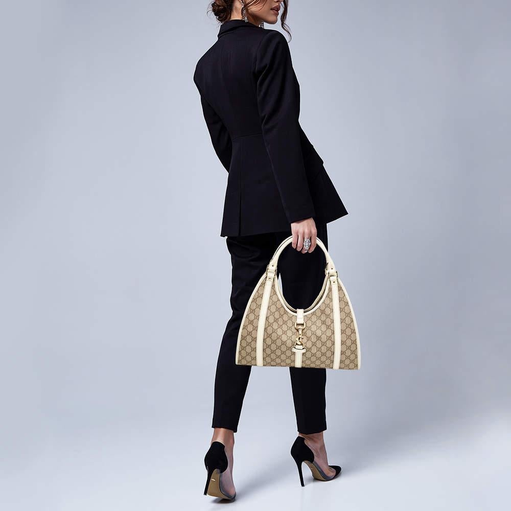This Gucci Joy bag is a must have to be added to your collection! Made from GG Supreme canvas with patent leather trim, it features a push lock toggle closure and two leather rolled handles. The interior is lined with fabric.

Includes
Original