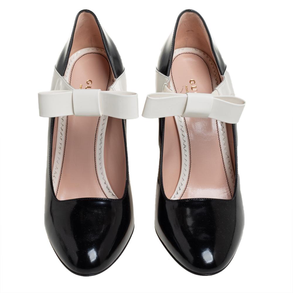 Feel fashionable while flaunting these patent leather classy and vintage pumps. Crafted from patent leather in black and white hues, these mary jane pumps feature almond toes and bows on the vamps. They are elevated on block heels for the right