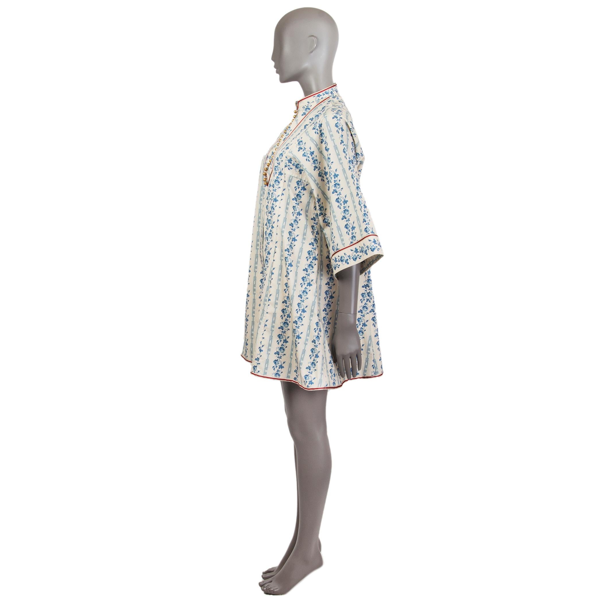 Gucci 3/4-sleeve porcelain print mini dress in off-white and blue cotton (97%) and elastane (3%) with a mandarin collar that has gold-tone buttons which fasten up on the front. Has a red and off-white fabric detail around the collar, cuffs, and