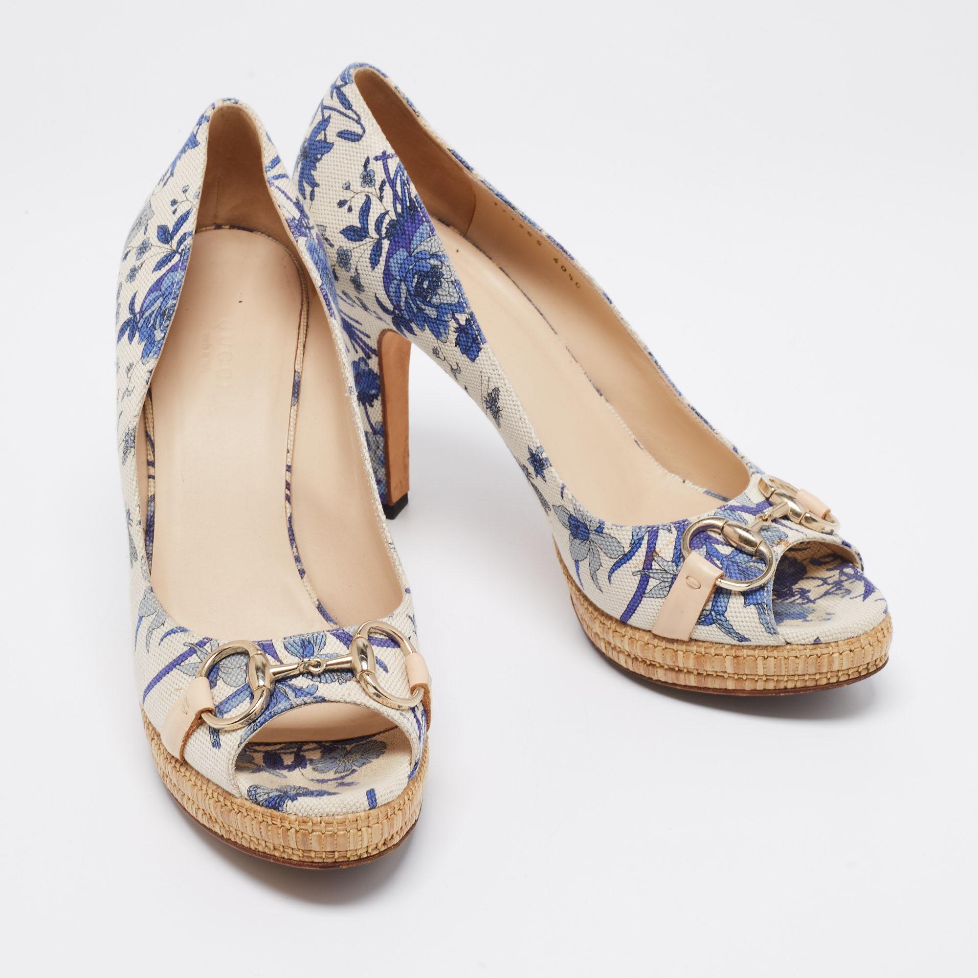 Adorned with a beautiful floral print and Gucci's aesthetics, these pumps will grant your feet unending charm, femininity, and poise! They are crafted using white-blue canvas, with gold-tone Horsebit motifs perched on the peep-toes. They have a