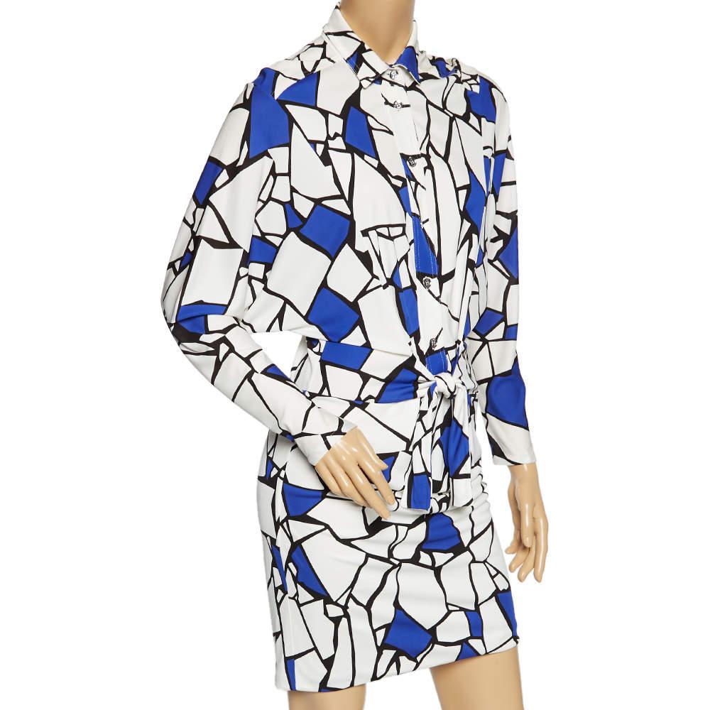 A feminine flair, eye-catching prints, and a timeless silhouette characterize this Gucci dress. Made using quality materials, it has front button closure, a simple collar, long sleeves, and a tie at the waist.