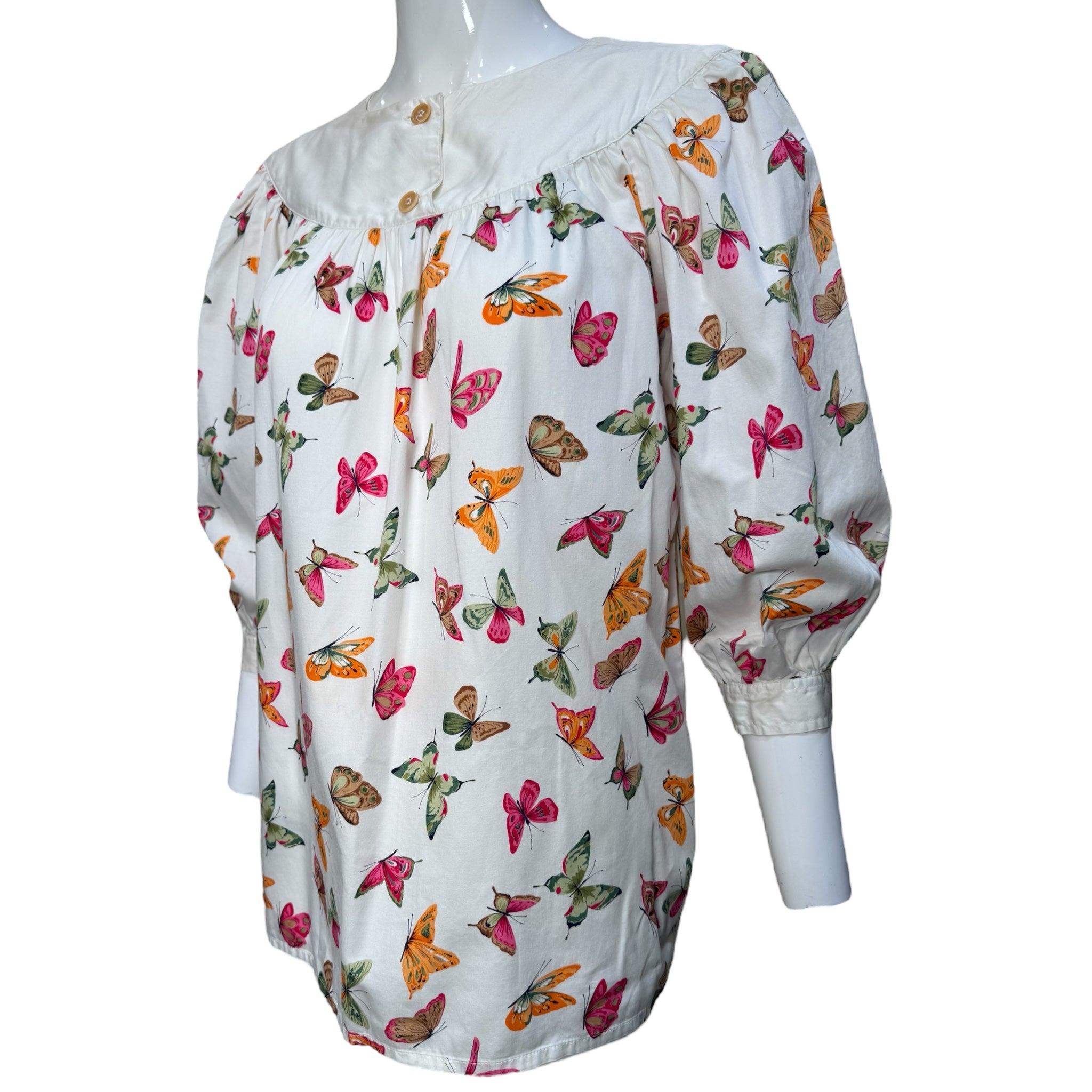 Gucci Baumwollbluse mit Schmetterlingsmuster, ca. 1970. Weiße Baumwolle mit einem aufgedruckten Schmetterlingsmotiv in Rosa, Orange, Gelb und Grün. Kombinieren Sie dazu einen Schal mit 'Flora'-Druck von 1966 und machen Sie sich auf den Weg zu den