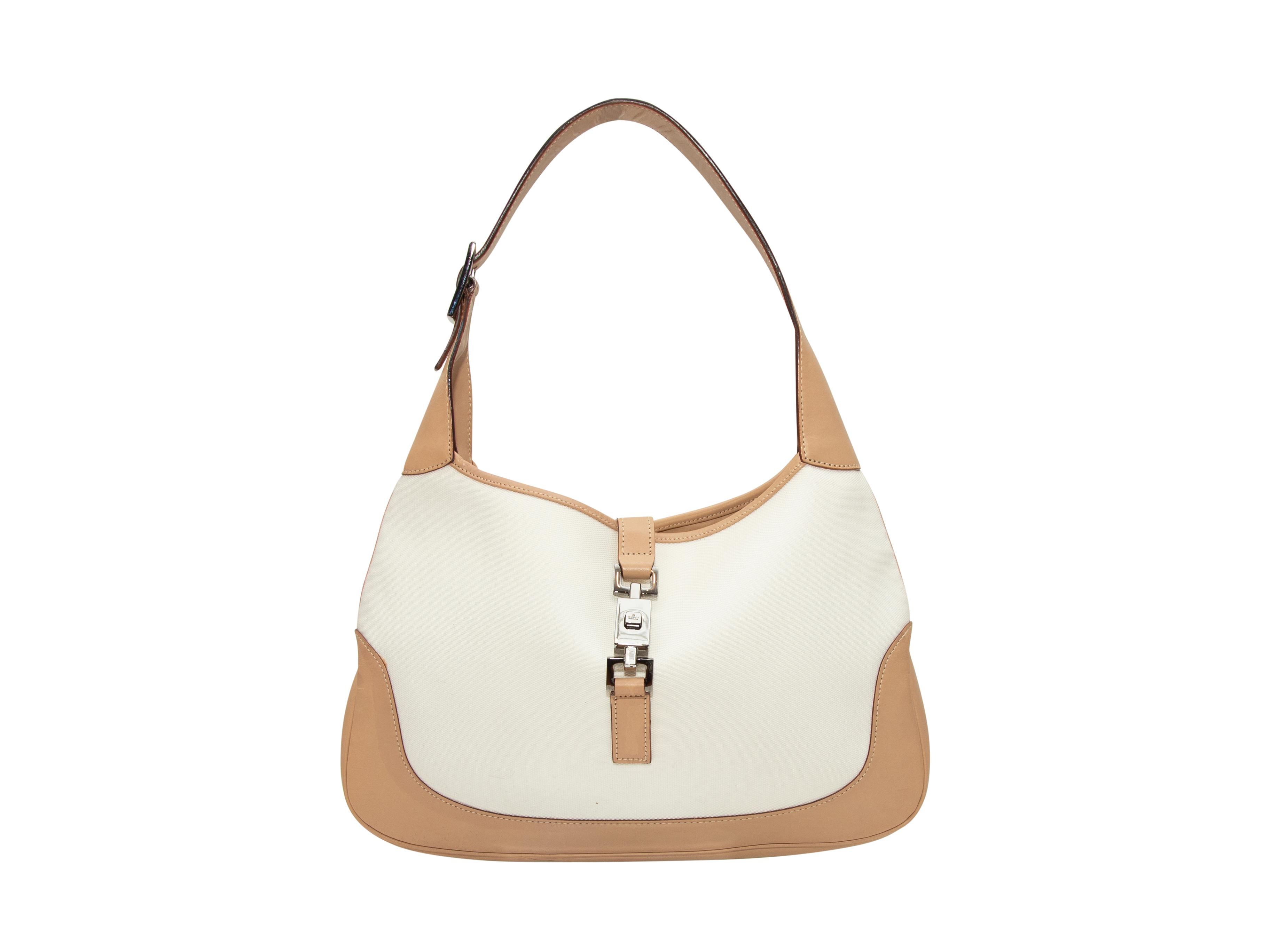 Product Details: Vintage White Gucci Canvas & Leather Jackie Bag. The Jackie Bag features a canvas body, tan leather trim, silver-tone hardware, a single shoulder strap, an interior zip pocket, and a buckle closure at the front. 13