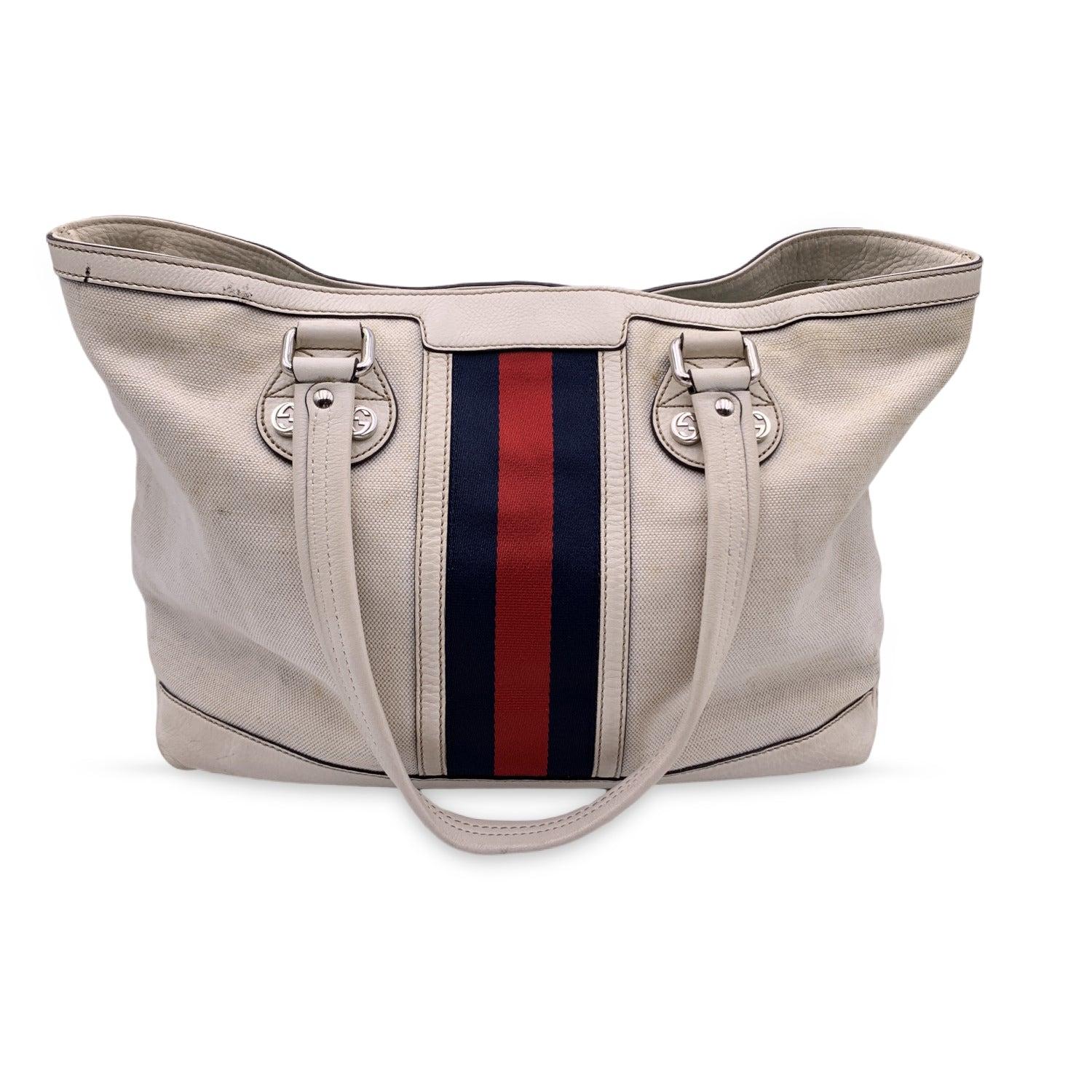 This beautiful Bag will come with a Certificate of Authenticity provided by Entrupy. The certificate will be provided at no further cost GUCCI white canvas Web Sunset Tote bag. This tote is crafted of white canvas with blue/red/blue signature