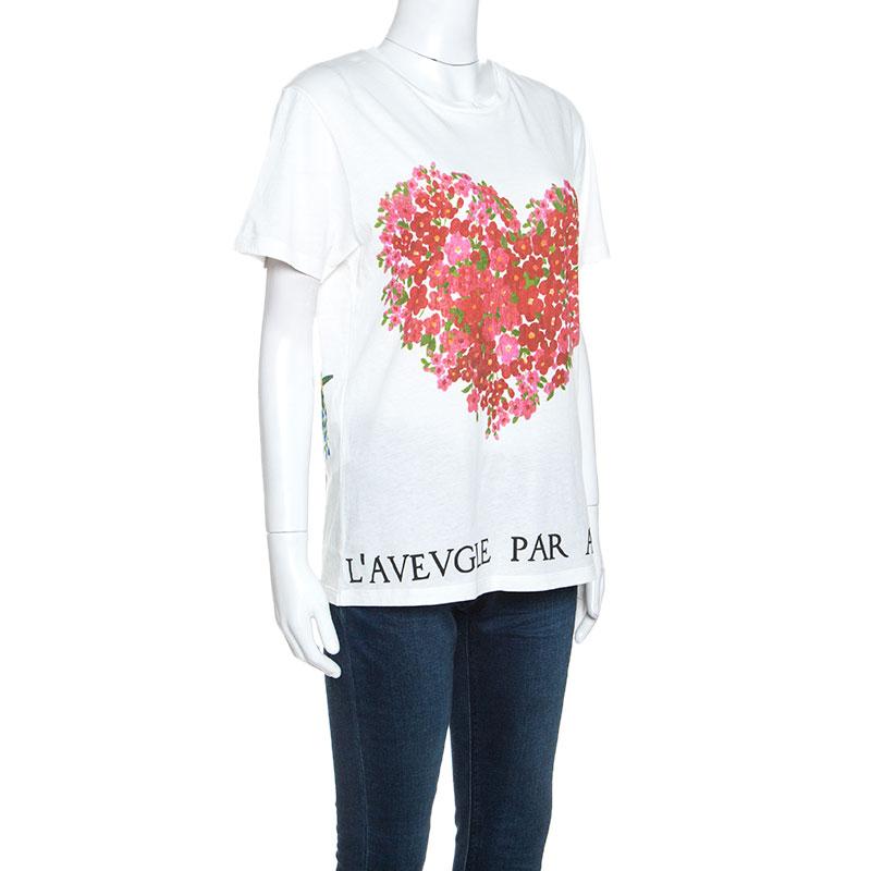 Draw everyone's attention with this sophisticated T-shirt from Gucci! Made from 100% cotton, it flaunts floral patterns designed in a heart and parrot shape on the front and back. It features a round neck, short sleeves, and 'L'Aveugle Par Amour'