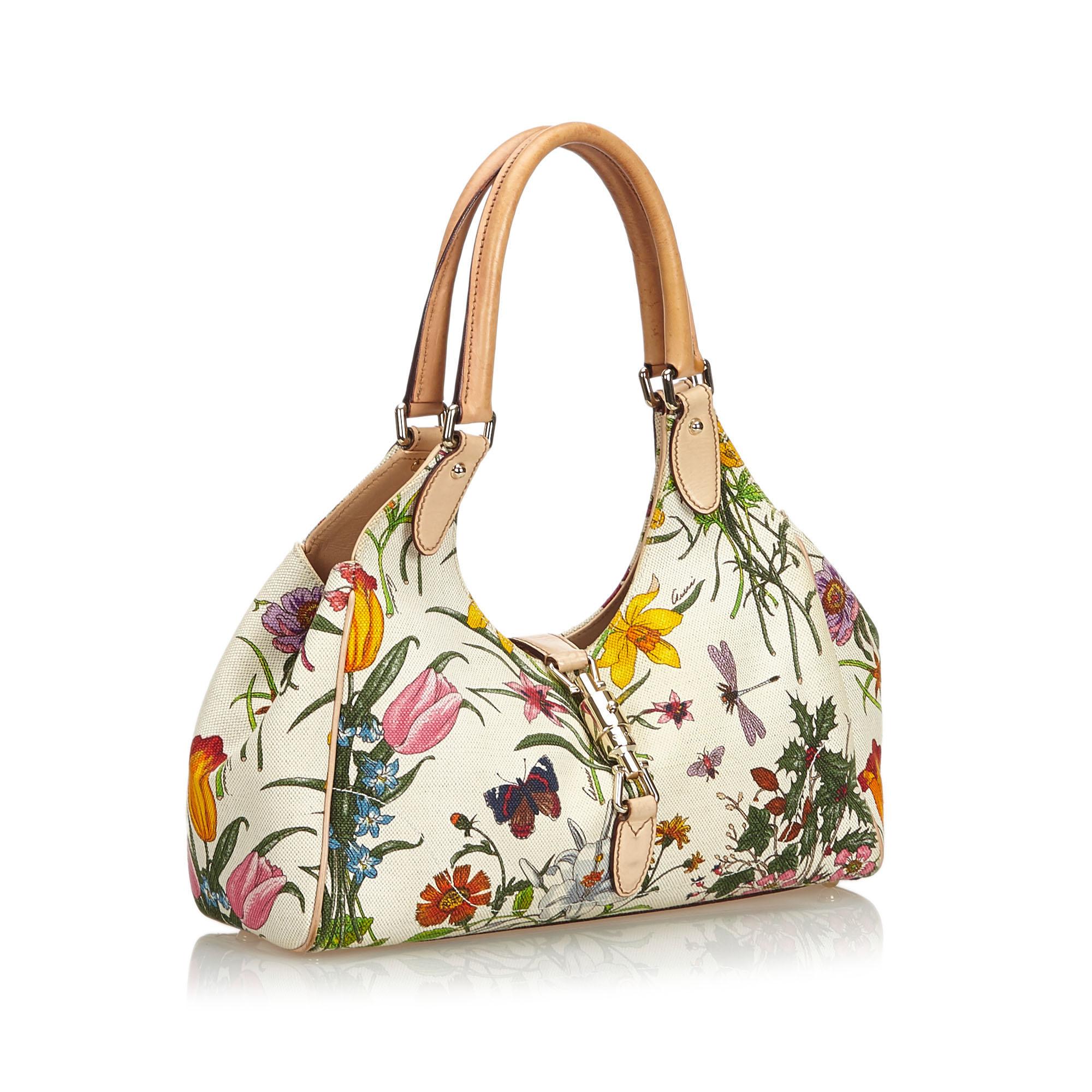 The New Jackie features a floral print on a canvas body, rolled leather straps, a leather strap with a lock closure, and an interior zip pocket. It carries as B condition rating.

Inclusions: 
This item does not come with