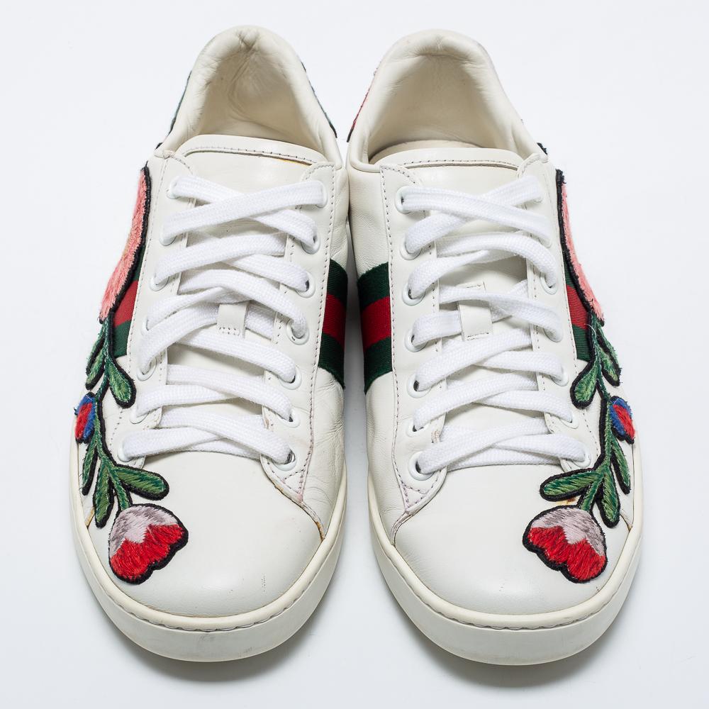 Stacked with signature details, this Gucci pair is rendered in white leather and is designed in a low-cut style with lace-up vamps. They have been fashioned with the iconic web stripes and covered in floral embroidered patches. Complete with red and