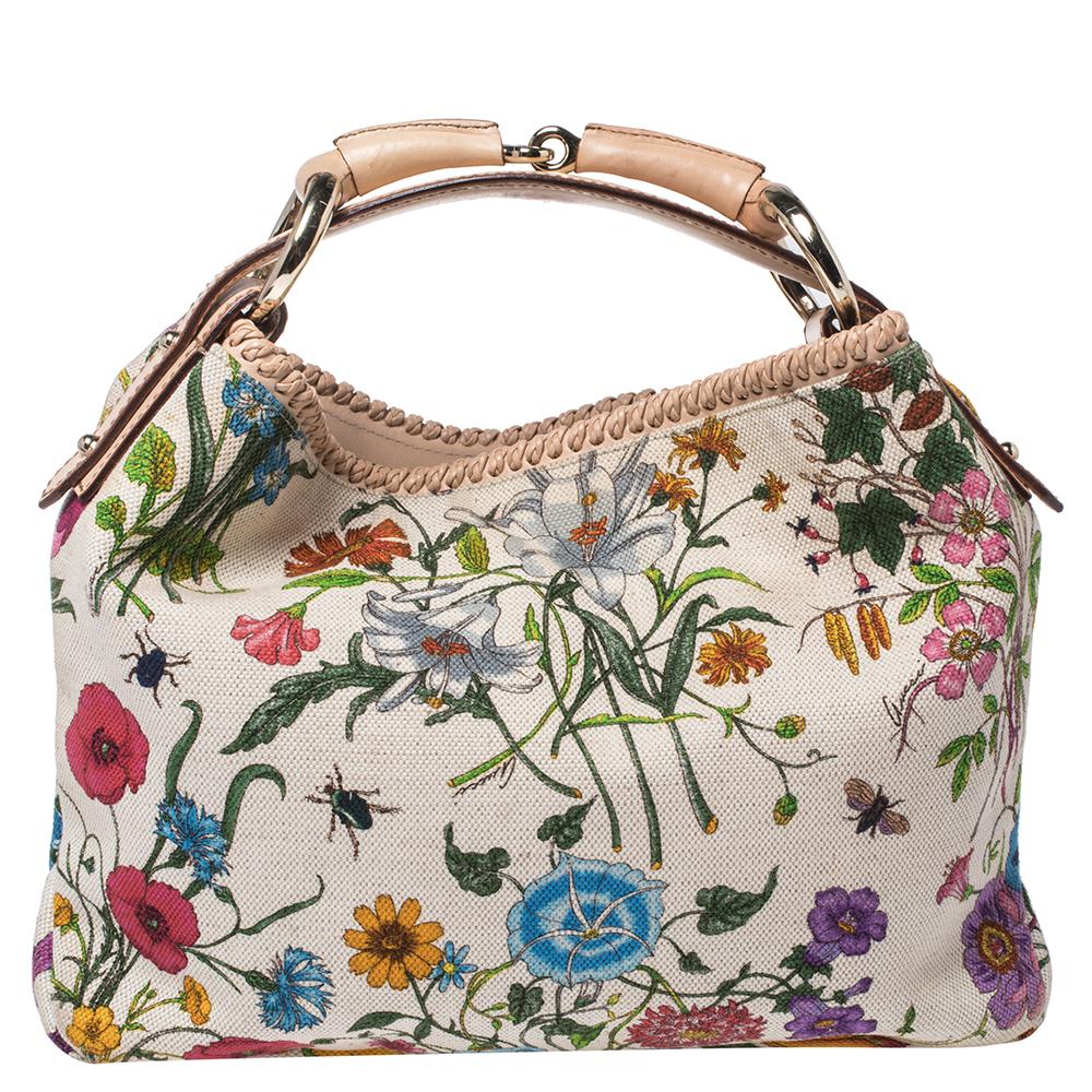 Gucci's handbags are not only well-crafted but they are also coveted because of their high appeal. This hobo bag, like all of Gucci's creations, is fabulous and closet-worthy. It has been crafted from white floral printed canvas and leather and