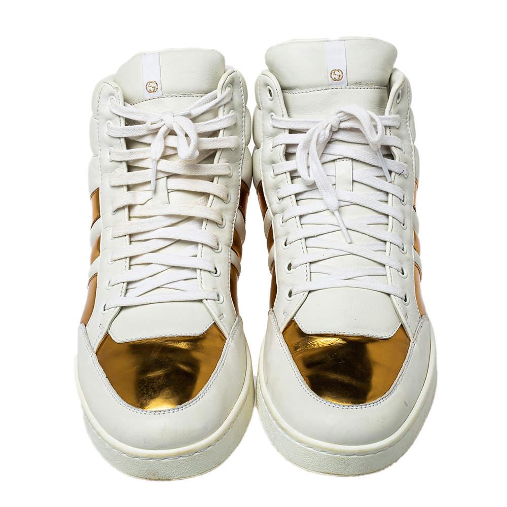 These Gucci sneakers just uplift the style quotient to a new level. Crafted with quality leather, this pair features horizontal quilting on the counters. In the dual tones of white and gold, this creation has a front lace closure with a comfortable