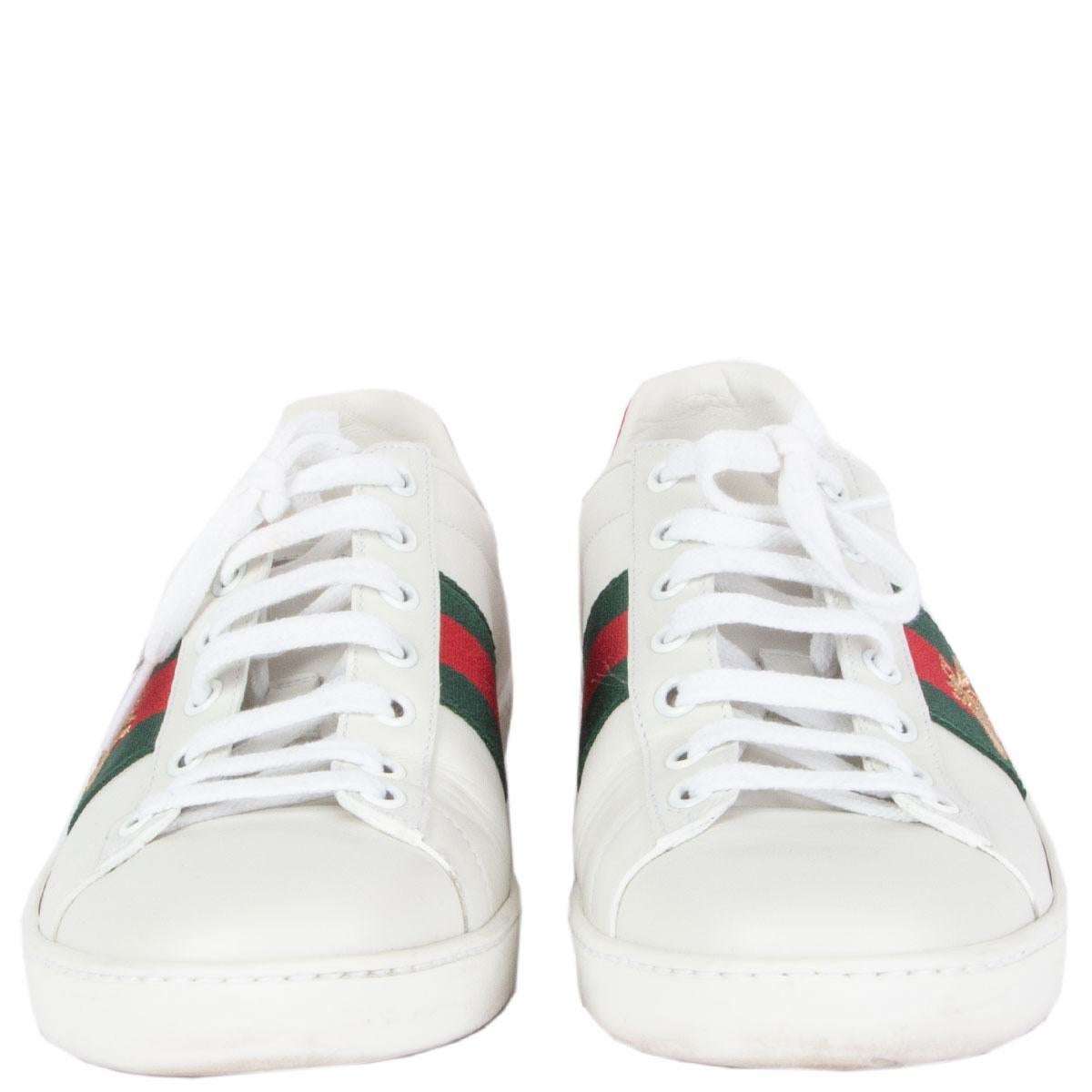 100% authentic Gucci Ace Bee sneakers in white leather features the label's signature stripes at the side with a gold metallic embroidered bee. Panels of shining snakeskin in red and green at the heels. Have been worn and are in excellent condition.