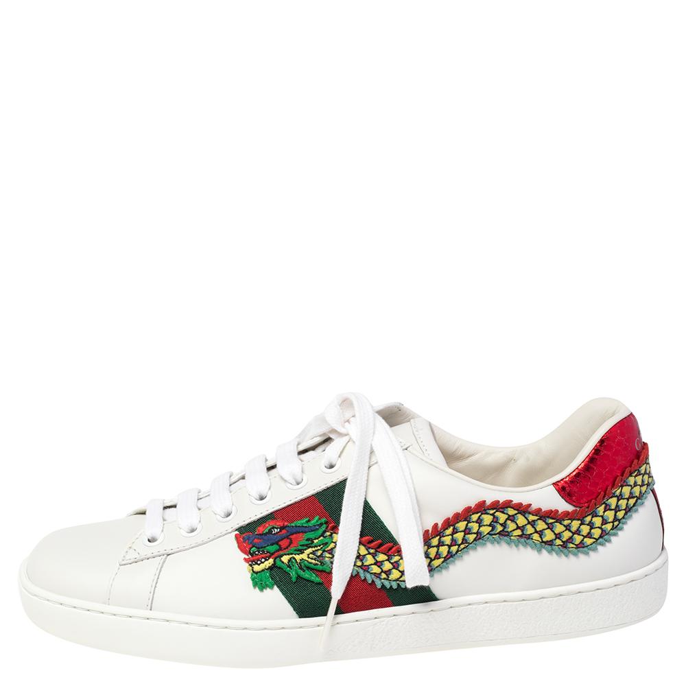 Stacked with signature details, this Gucci pair is rendered in leather and is designed in a low-cut style with lace-up vamps. They have been fashioned with the iconic web stripes and dragon motifs embroidered on the exterior. Complete with red and
