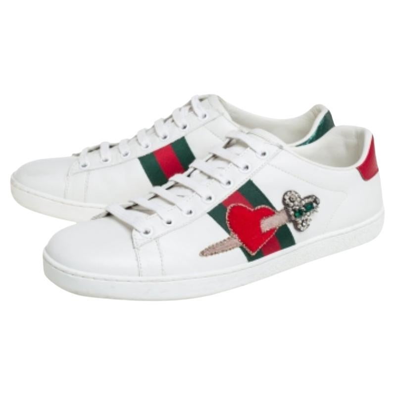 Stacked with signature details, this Gucci pair is rendered in leather and is designed in a low-cut style with lace-up vamps. The white sneakers have been fashioned with the iconic web stripes and embellished arrow and red heart motifs on the sides.