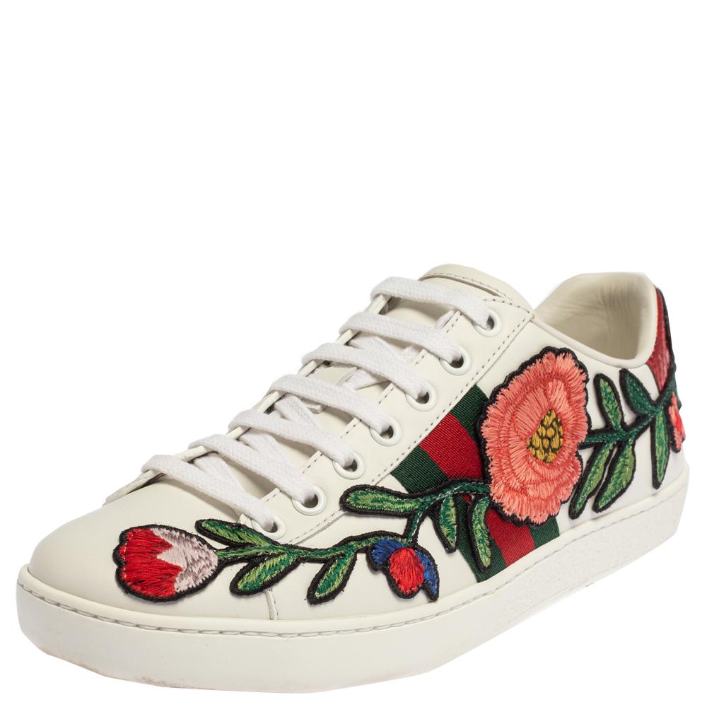 These ultra-cool Ace sneakers from Gucci are edgy and comfortable. Made from white leather, the shoes feature gorgeous floral-embroidered designs on the side panels and tie detailing on the rear side. These low-top sneakers are complete with round