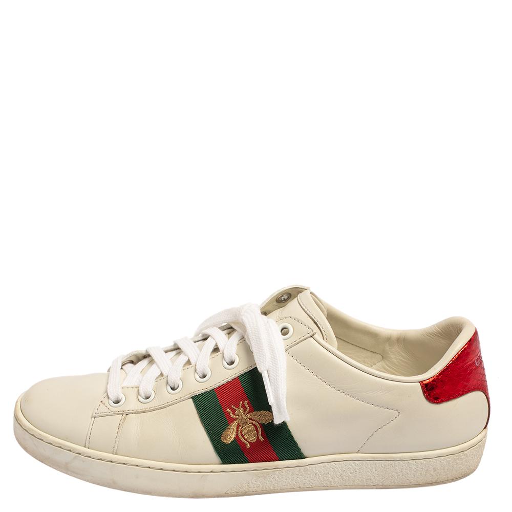 Stacked with signature details, this Gucci pair is rendered in leather and is designed in a low-cut style with lace-up vamps. They have been fashioned with the iconic web stripes and bee embroidery on the sides. Complete with red and green snake