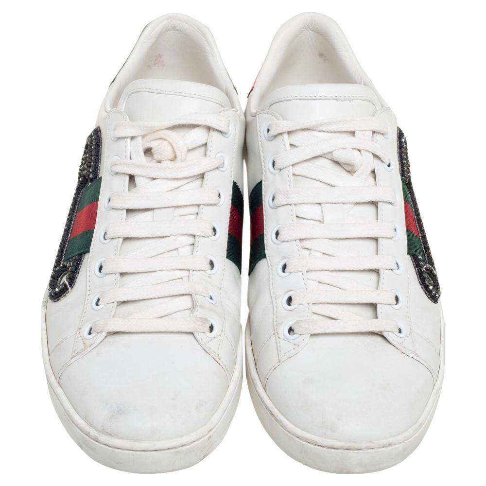 Stacked with signature details, this Gucci pair is rendered in black leather and is designed in a low-cut style with lace-up vamps. The sneakers have been fashioned with iconic web stripes and embellished safety pin motifs. Complete with red and