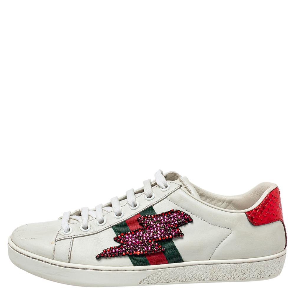 Stacked with signature details, this Gucci pair is rendered in leather and is designed in a low-cut style with lace-up vamps. The white sneakers have been fashioned with the iconic web stripes and crystal-embellished lighting bolt appliqués on the