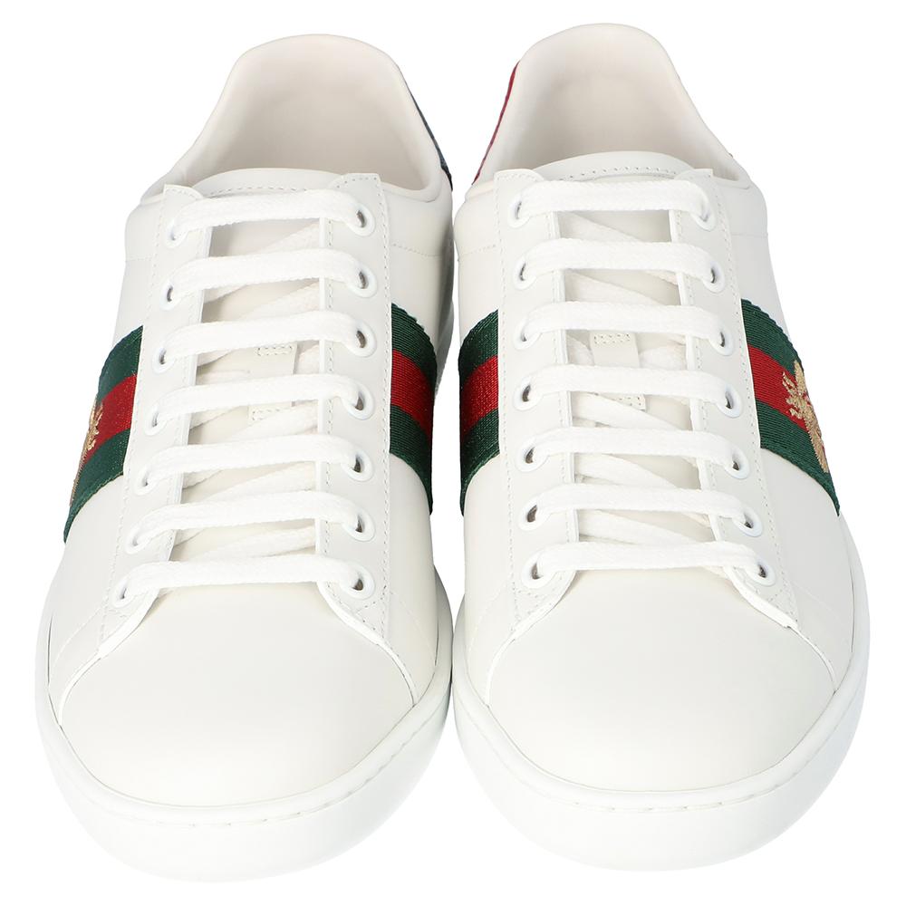 Stacked with signature details, this Gucci pair is rendered in white leather and designed in a low-cut style with lace-up vamps. They have been fashioned with the iconic web stripes joined by embroidered bees. Complete with red and green trims
