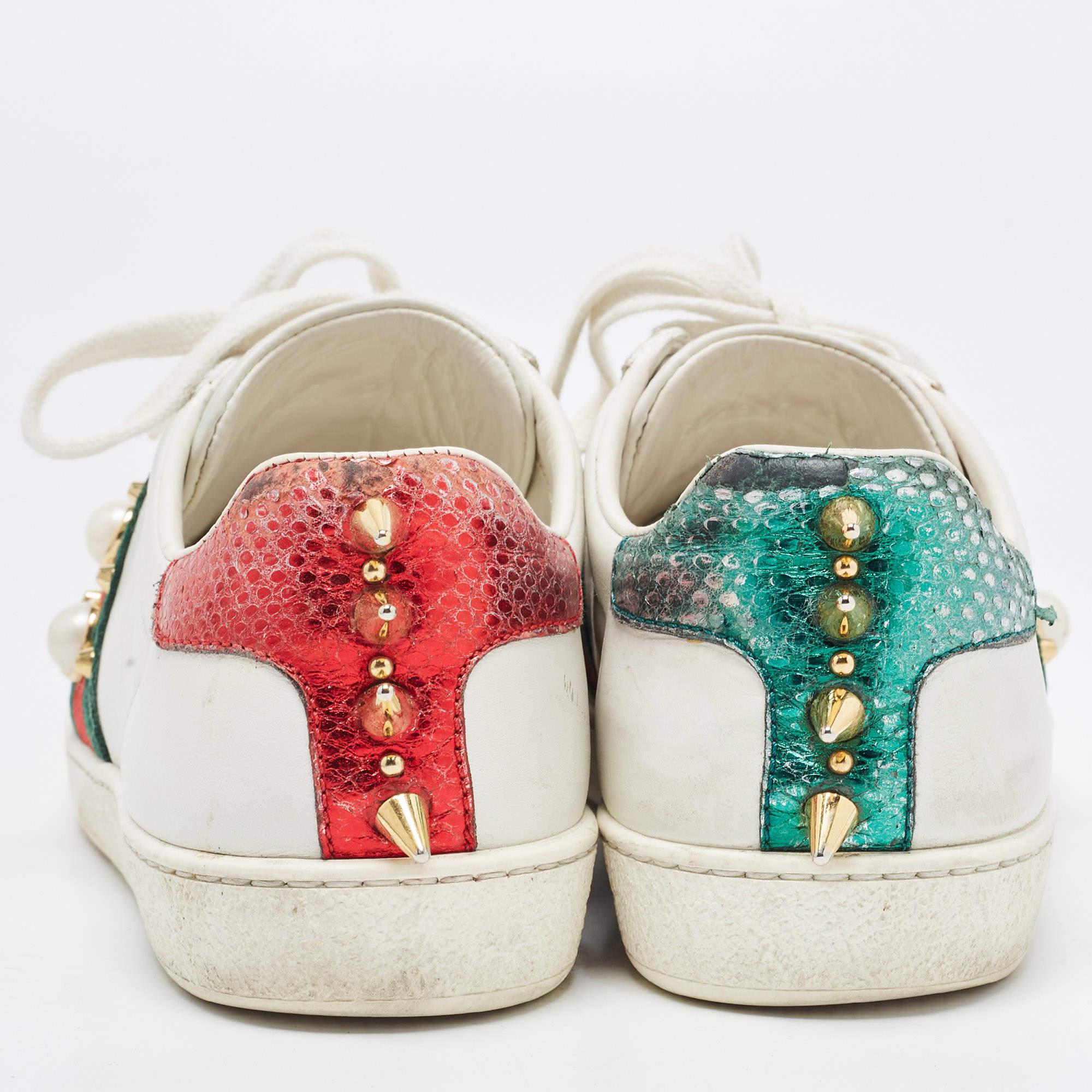 Dieses Gucci Paar aus Leder ist mit charakteristischen Details versehen und hat einen tiefen Ausschnitt. Die Sneaker sind mit Schnürsenkeln auf dem Obermaterial, dem kultigen Webstreifen mit Kunstperlen und Nieten an den Seiten und