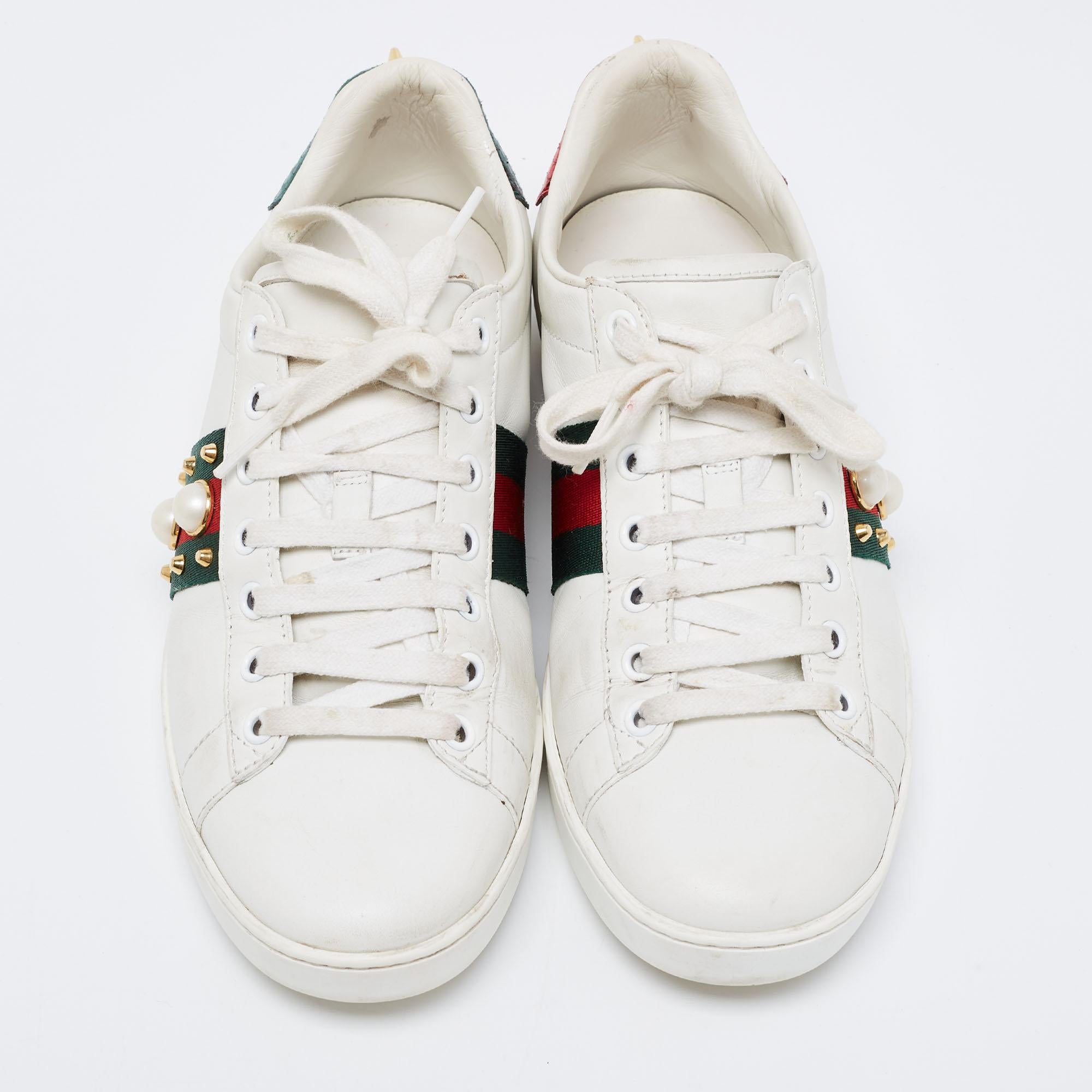 Stacked with signature details, this Gucci pair is rendered in leather and is designed in a low-cut style with lace-up vamps. They have been fashioned with iconic web stripes, studs, and faux pearls on the sides. Complete with red and green
