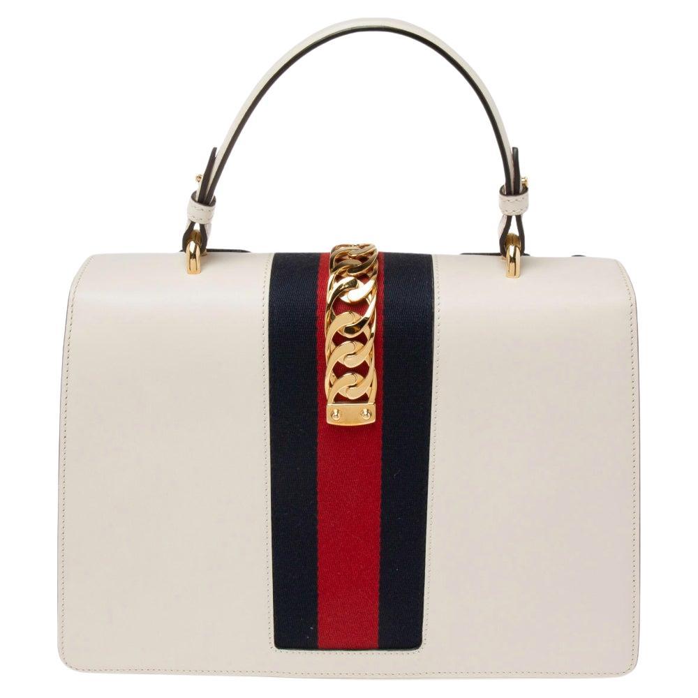 This Sylvie bag from the house of Gucci is much loved by fashionistas and a beautiful statement piece to own. Crafted from leather, the white bag has lovely floral embroidery on the front and comes with gold-tone detailing. It opens into a