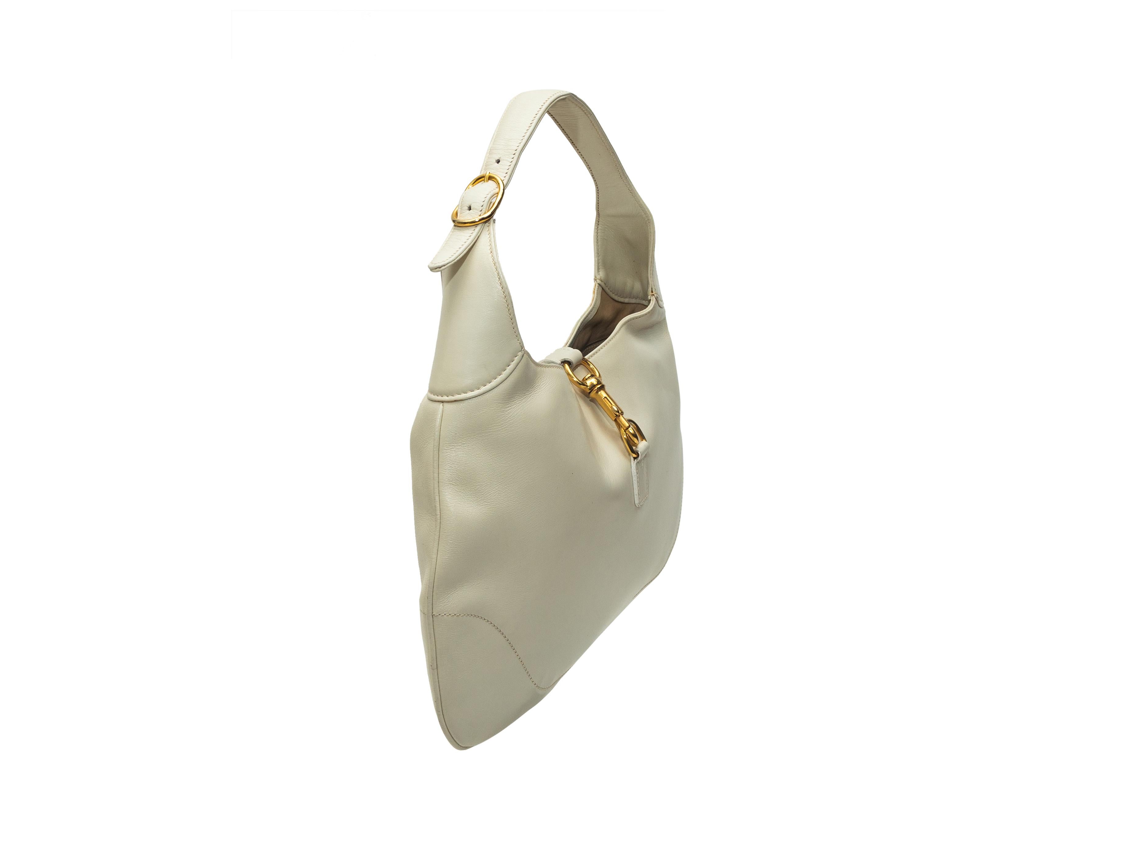 Product details: Vintage white leather Jackie O hobo bag by Gucci. Gold-tone hardware. Interior zip pocket. Buckle closure at top. 16