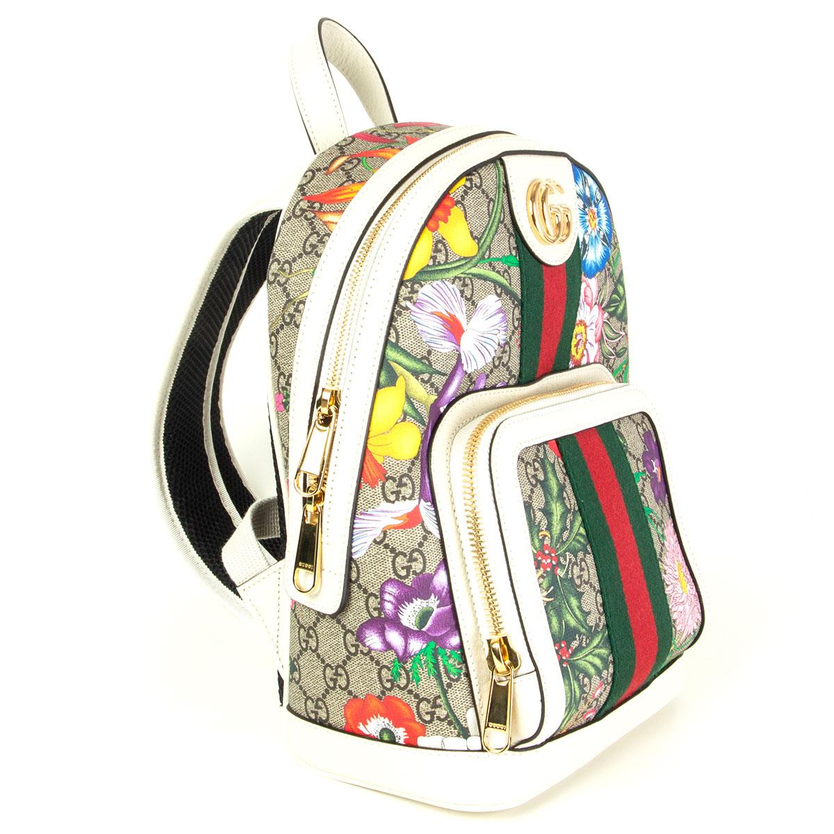 Gucci backpack in coated canvas featuring logo pattern in beige and brown. Multicolor floral pattern and grained leather trim in white throughout. Leather carry handle at top. Twin padded adjustable shoulder straps. Signature striped webbing trim in