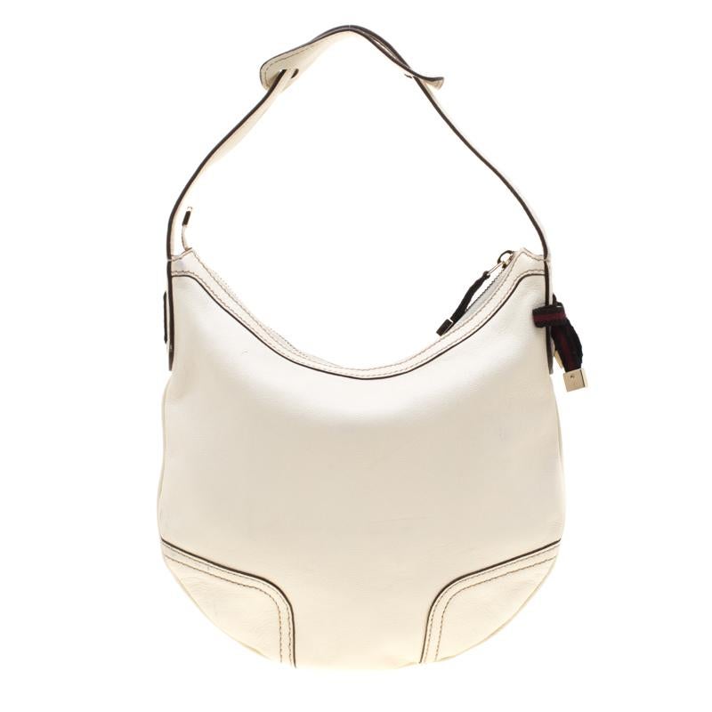 Crafted from white leather, this Princy hobo from Gucci is designed with minimal style details but with high attention to craftsmanship so that it may assist you with durability. The spacious interior of the bag is lined with fabric and secured by a