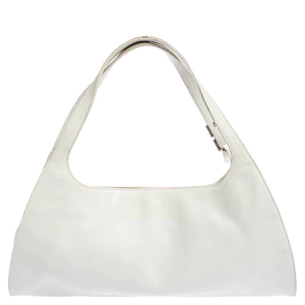 Sleek and stylish, this shoulder bag is an absolute classic that will complement a host of ensembles effortlessly. Crafted by Gucci, it comes in a shade of white and is made from quality leather in Italy. It is styled minimally with dual handles