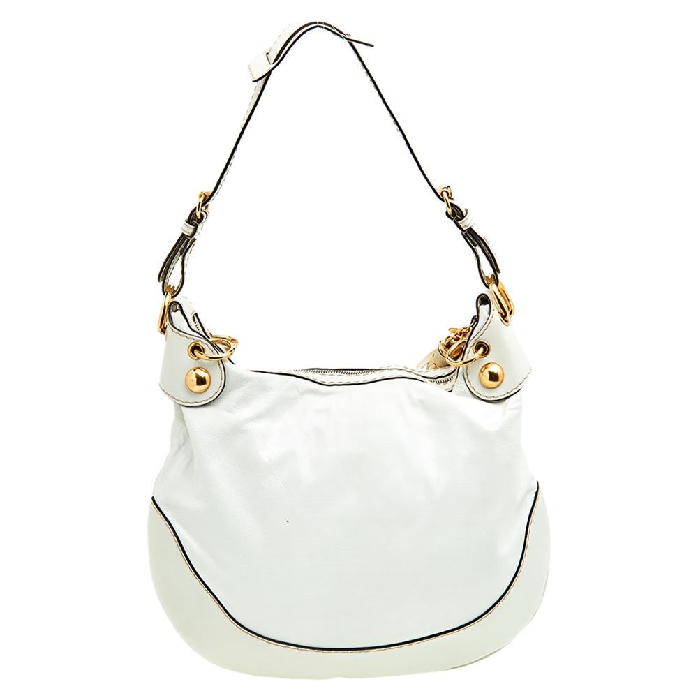This Gucci Babouska hobo creation might just become the most loved classic bag in your closet. Crafted from leather, it has gold-tone hardware, the signature tassel, stud details, and the heart emblem. The bag is equipped with a single handle and a