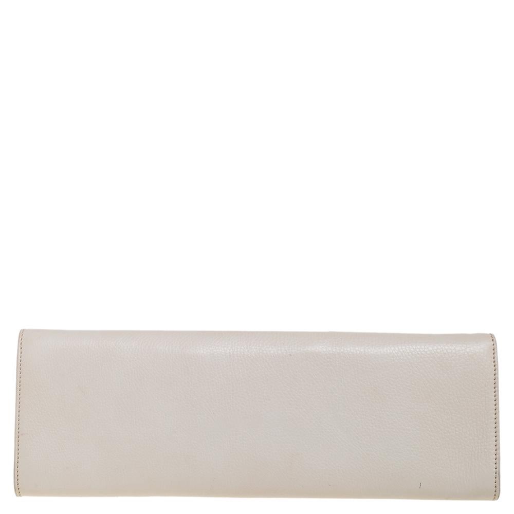 The house of Gucci brings you the perfect party clutch! Crafted skillfully from leather, the white piece is adorned with beautiful studs on the front and has a front flap that opens into a fabric interior with a zip pocket.

Includes: Info Booklet
