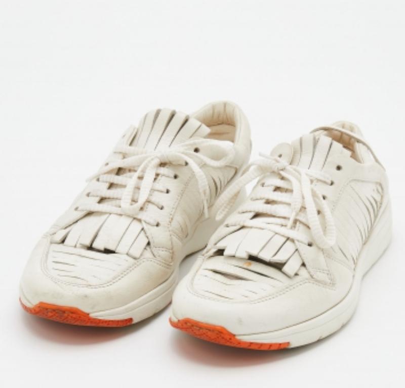 These chic white sneakers by Gucci are just what you need to grace your look. Crafted with leather, this pair comes with lace-ups accompanied by tassel detailing. It has snug insoles and is complete with durable rubber soles for ultimate comfort.