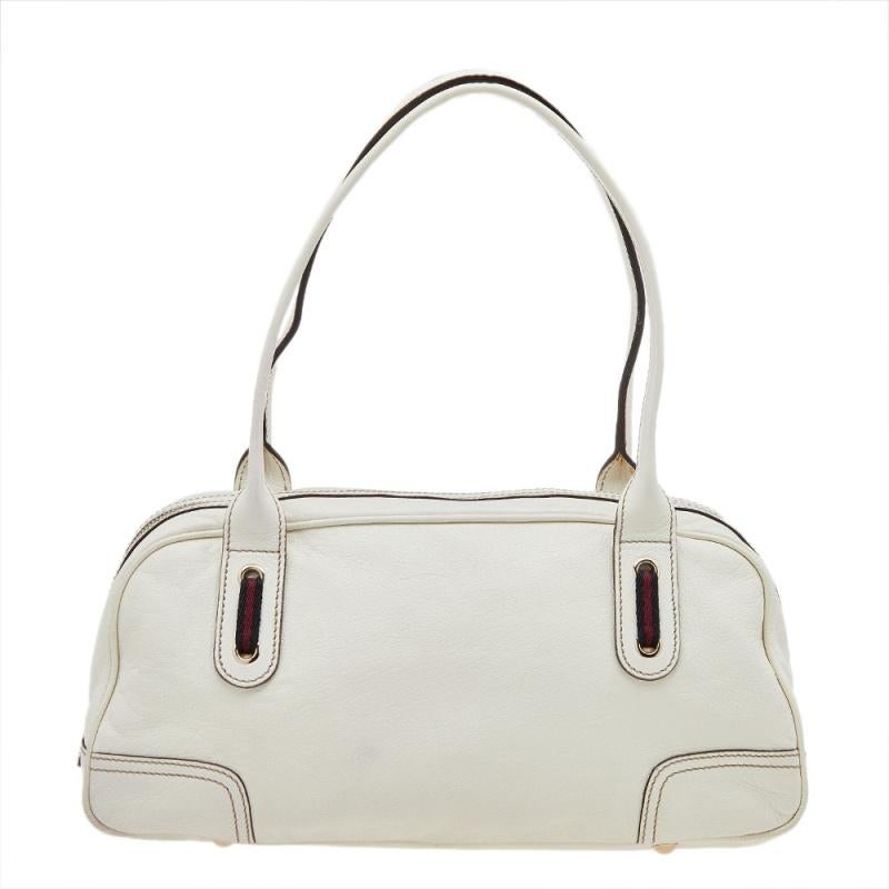 Add this elegant Gucci bowling bag to your collection for a style upgrade. It is white in color and made using leather, featuring a Web bow detail on the front. It is complete with dual handles and a capacious interior for your