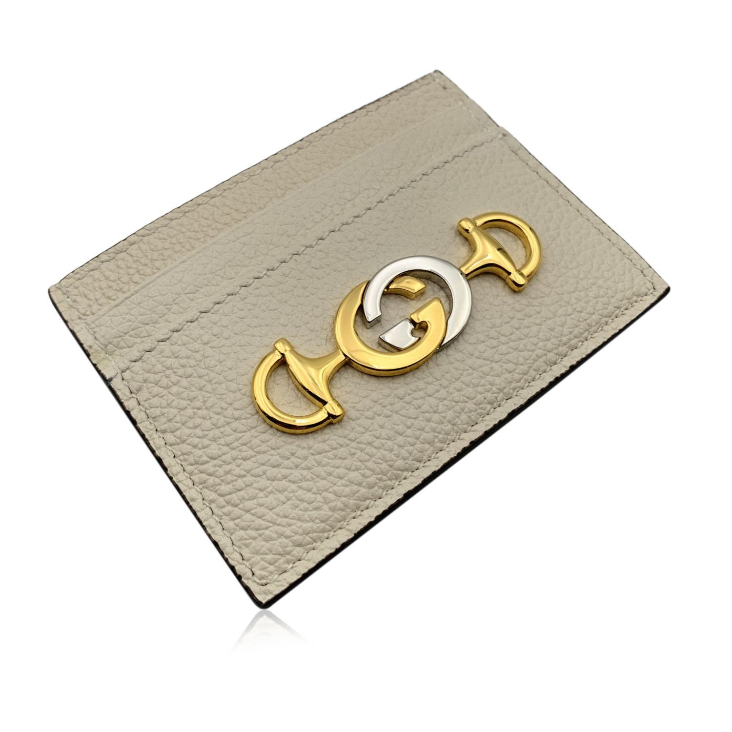 Beautiful Gucci 'Zumi' credit card holder wallet, crafted in white leather with gold and silver metal GG logo and horsebit detailing on the front. Leather and fabric interior. 1 middle open section and 4 credit card slots. 'Gucci - Made in Italy'