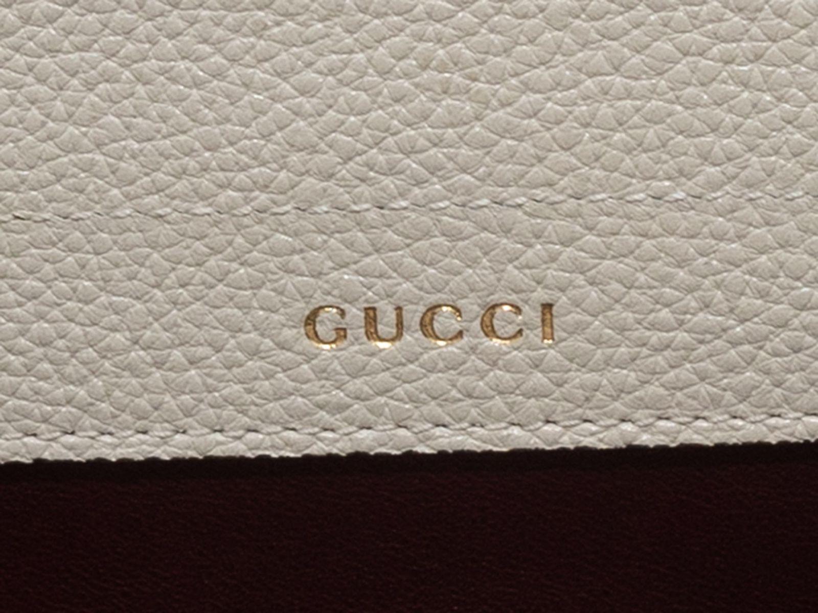 Product Details: White Gucci Medium Zumi Leather Handbag. The Zumi Handbag features a leather body, silver-tone and gold-tone hardware, dual interior zip pockets, dual flat top handles, a single flat shoulder strap, and front GG Horsebit adornment.