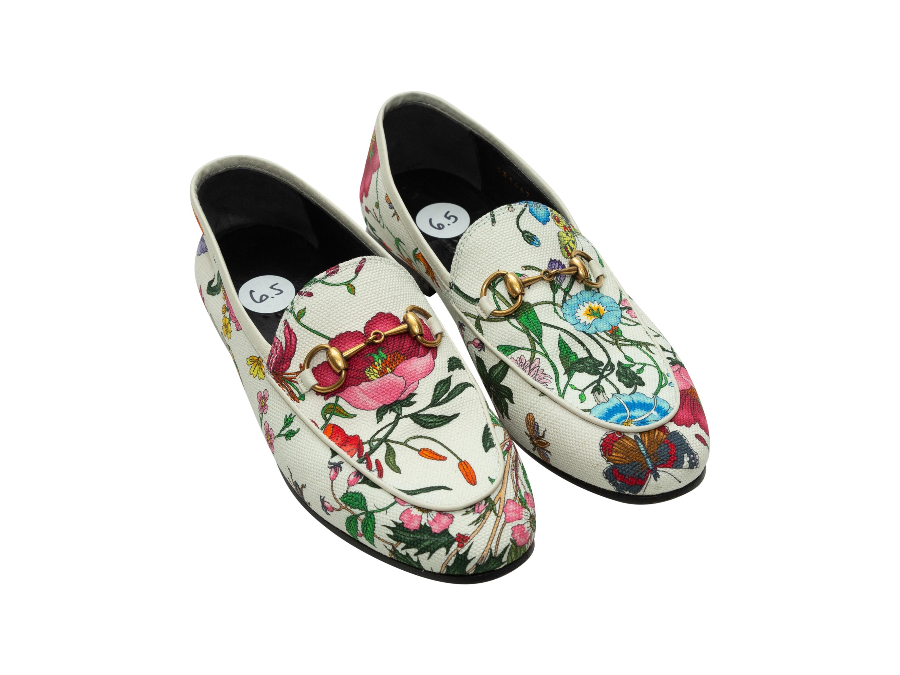 Product details: White and multicolor round-toe canvas loafers by Gucci. Multicolor Flora print throughout. Leather trim. Gold-tone horsebit accents at tops. Designer size 36.5. 0.5