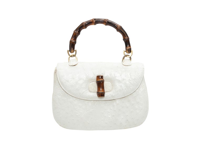 Product Details: Vintage White Gucci Ostrich Leather Handbag. This handbag features an ostrich leather body, gold-tone and bamboo hardware, a single bamboo top handle, and a bamboo toggle closure at front flap. 10